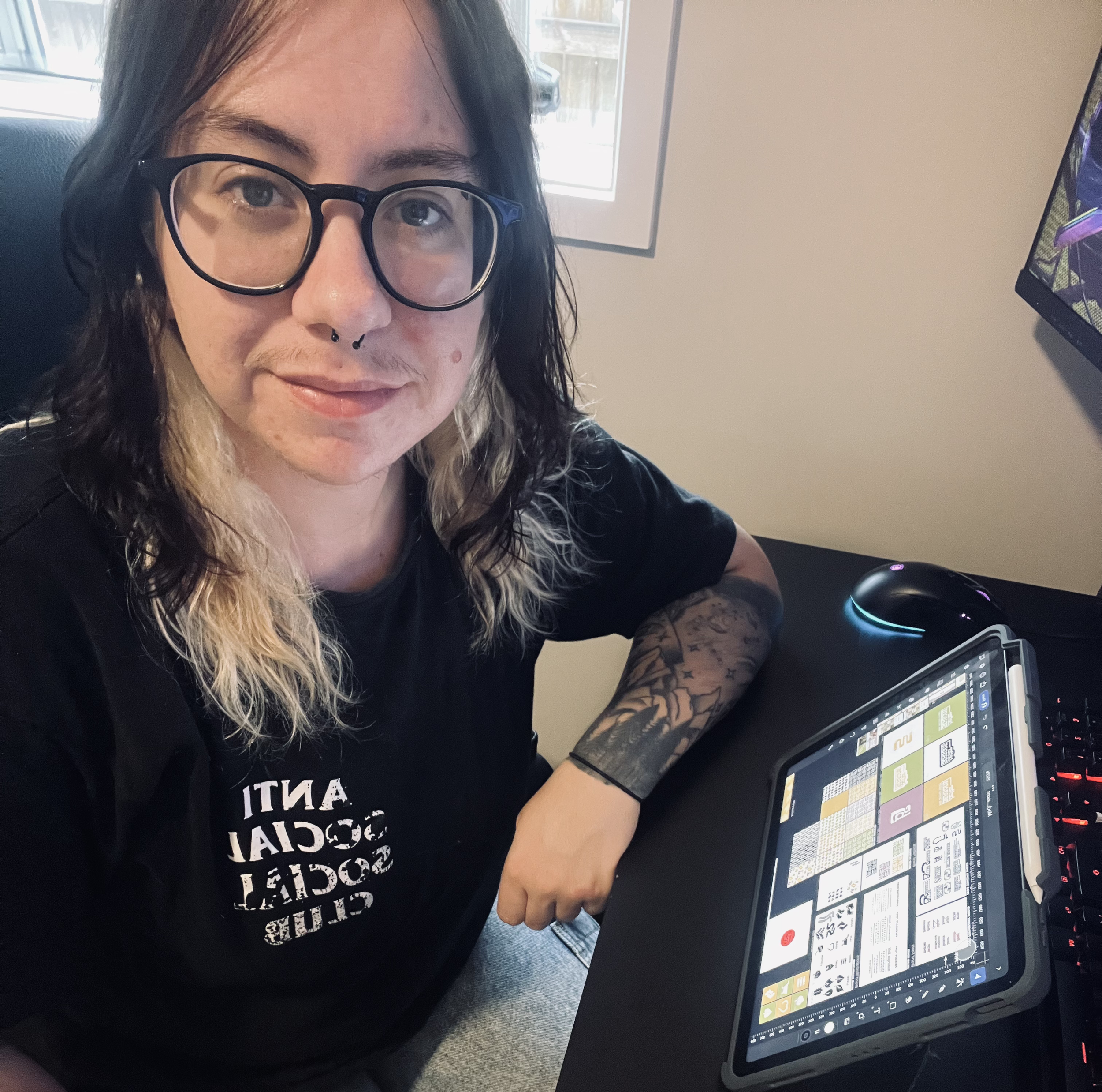 Image of designer, close-up, with an iPad in shot that features designs.