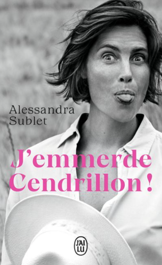 Une femme faisant une grimace avec la langue sortie et tenant un chapeau blanc. Texte en français : "Alessandra Sublet" et "J'emmerde Cendrillon !".