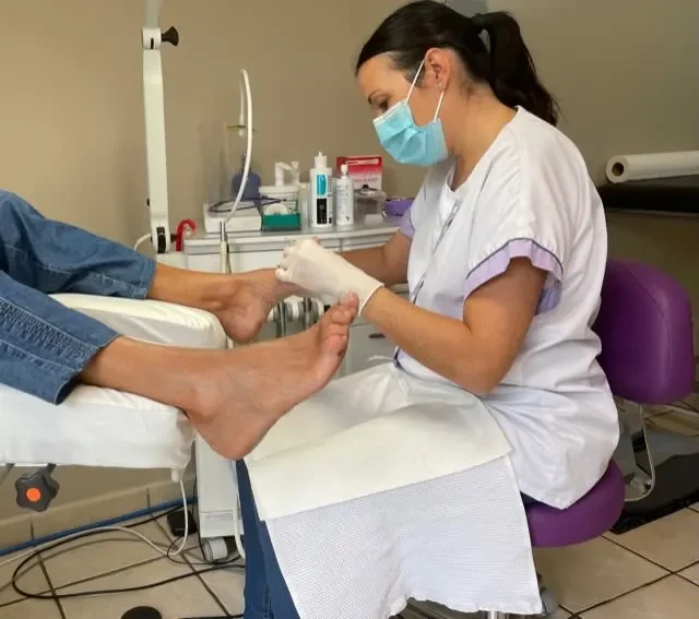 Une infirmière examinant le pied d'un patient dans un cabinet médical.