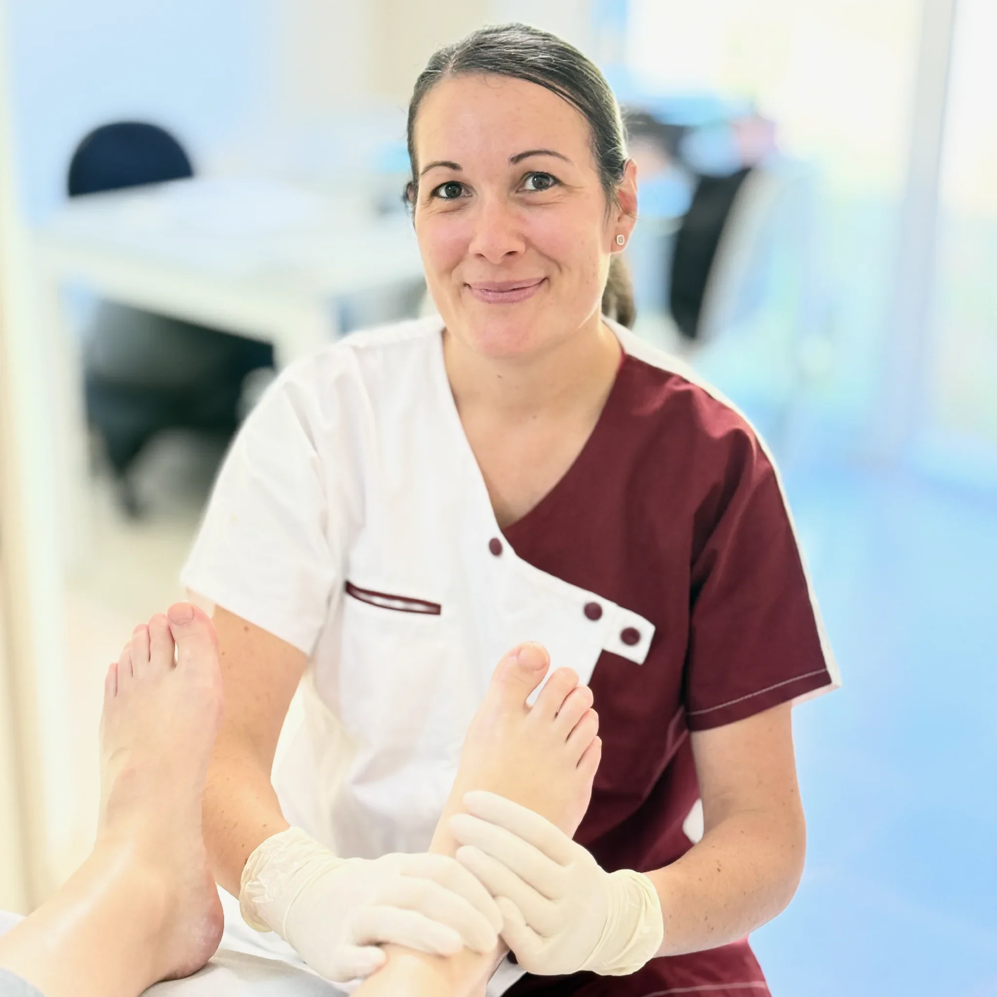 Une femme en uniforme médical recevant une injection dans le bras, tenant un pansement en bandage blanc, dans un environnement médical lumineux.