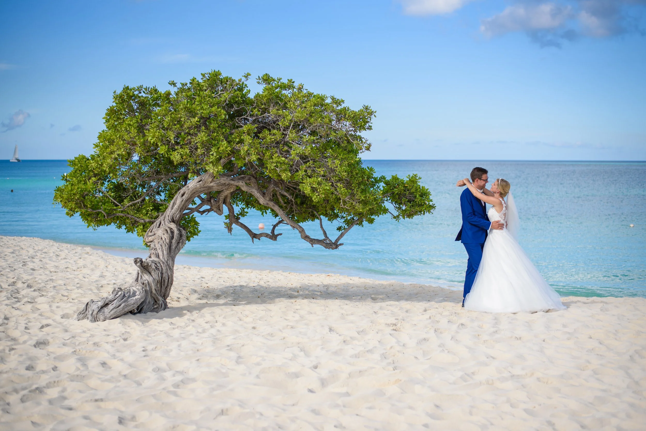 Close-up view of a sandy beach with clear, shallow water and intricate reflections on the surface. Wedding Couple