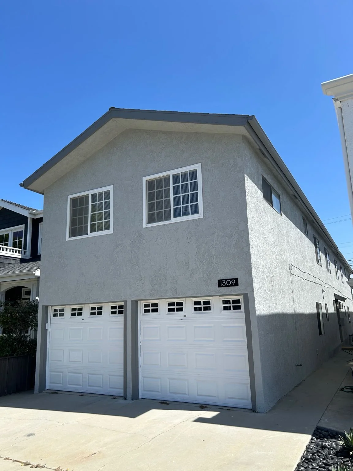 Multi family building painted in modern gray right next to the beach.