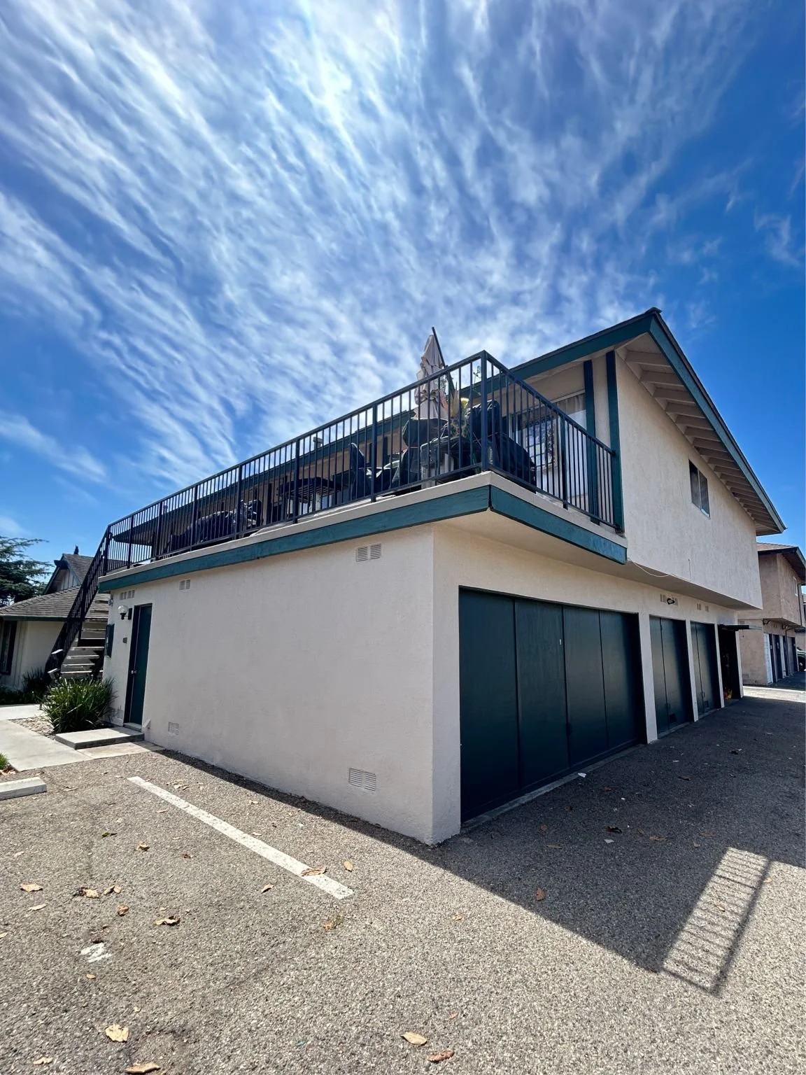 Cream colored multifamily building with dark green accents in Huntington Beach.