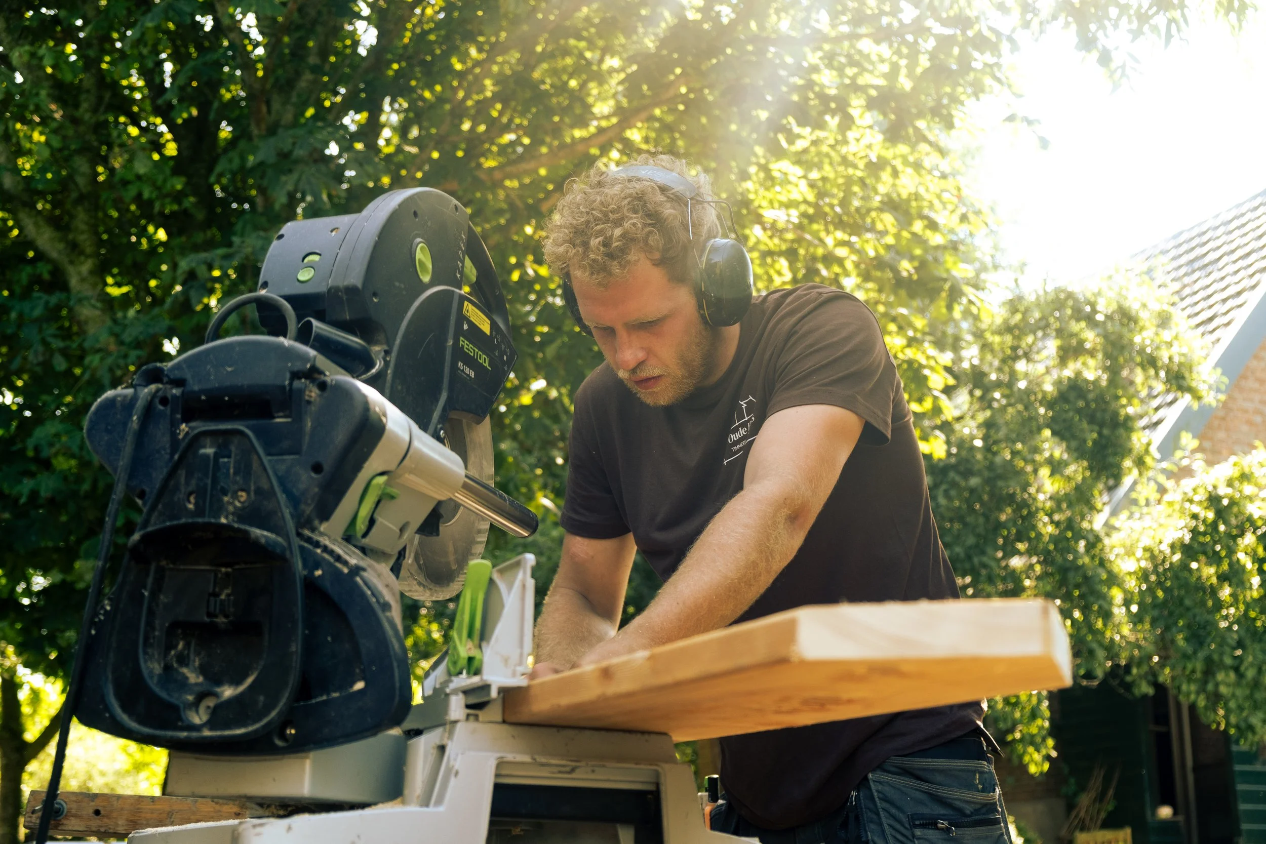 Oranssi carpenter using bench saw