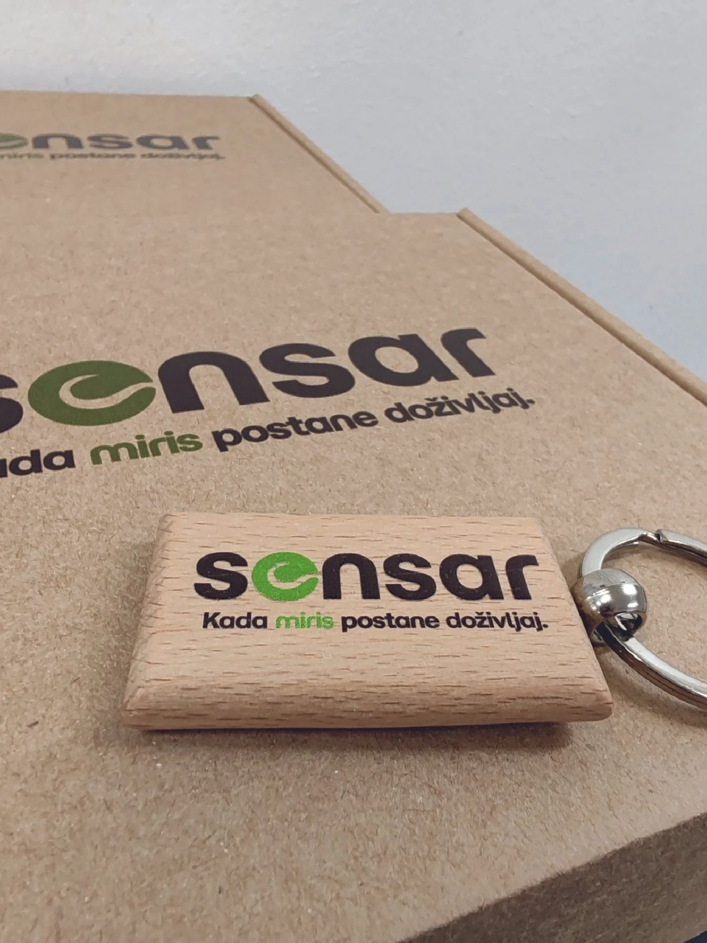 A wooden keychain with the word 'sensar' printed on it, and additional text in Turkish that translates to 'When the mind becomes alive.' A metal ring is attached to the keychain.