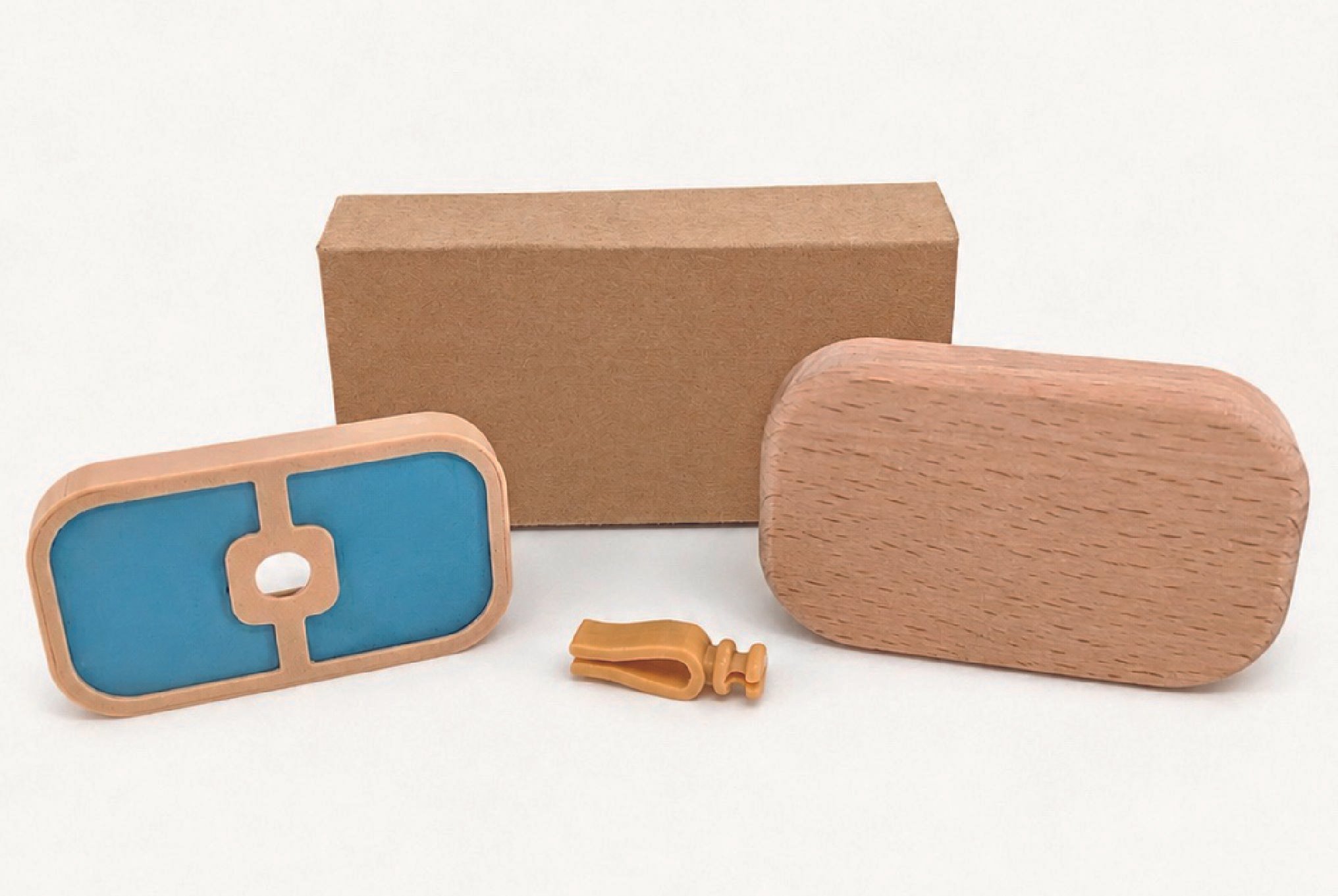 A set of wooden blocks and pieces, including a rectangular wooden block, a smaller rounded wooden piece, a rectangular piece with blue and orange sections, a small yellow wooden piece, and a small yellow key, arranged on a white background.