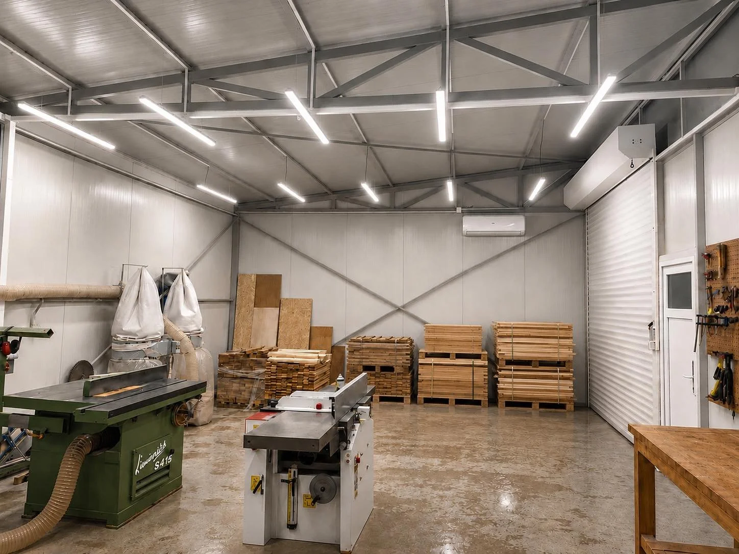 Interior of a woodworking workshop with stacks of lumber, woodworking machinery, and tools.