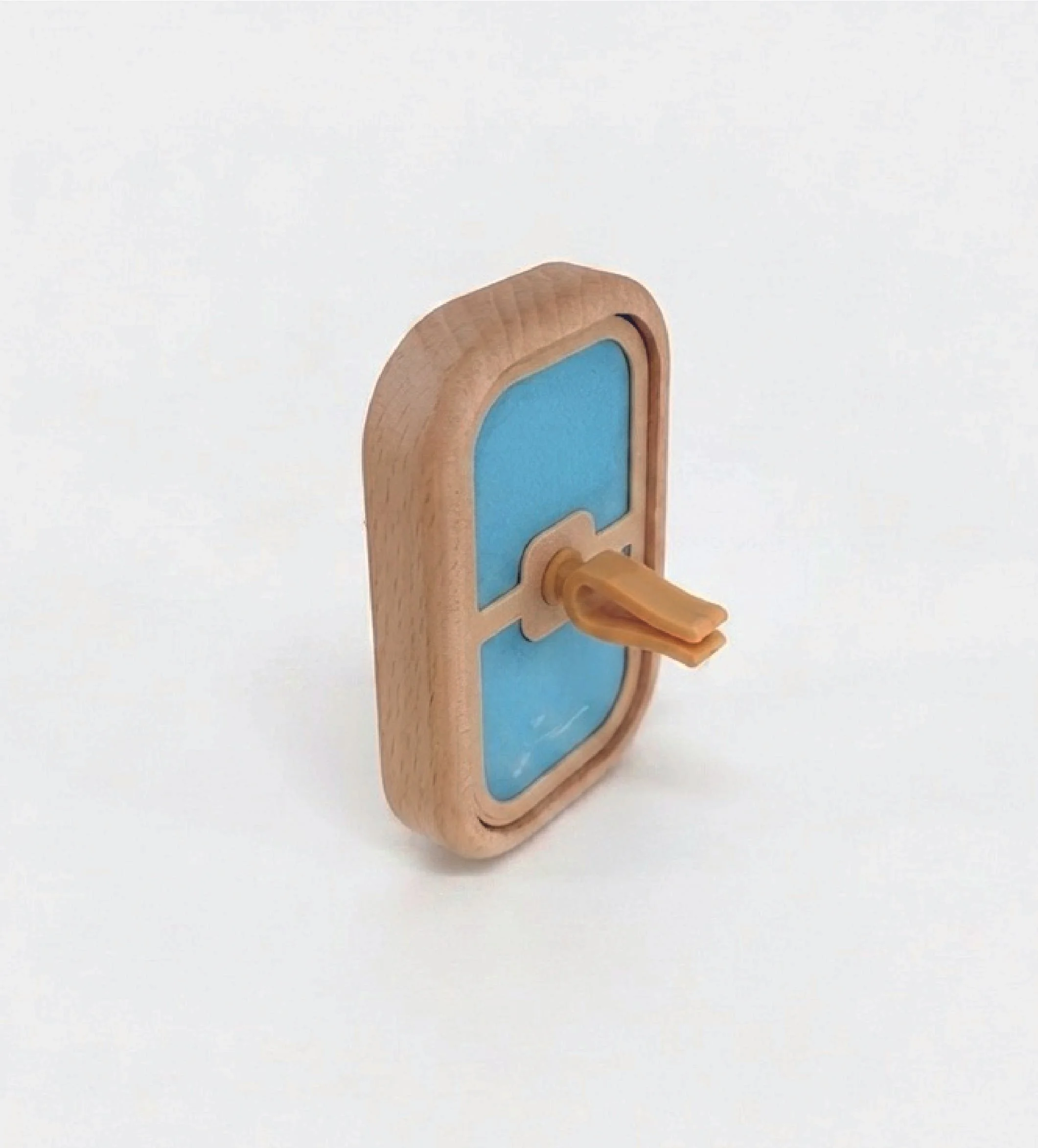 Close-up of a small wooden toy with a blue rectangular surface, a rounded top, and an orange wooden peg.