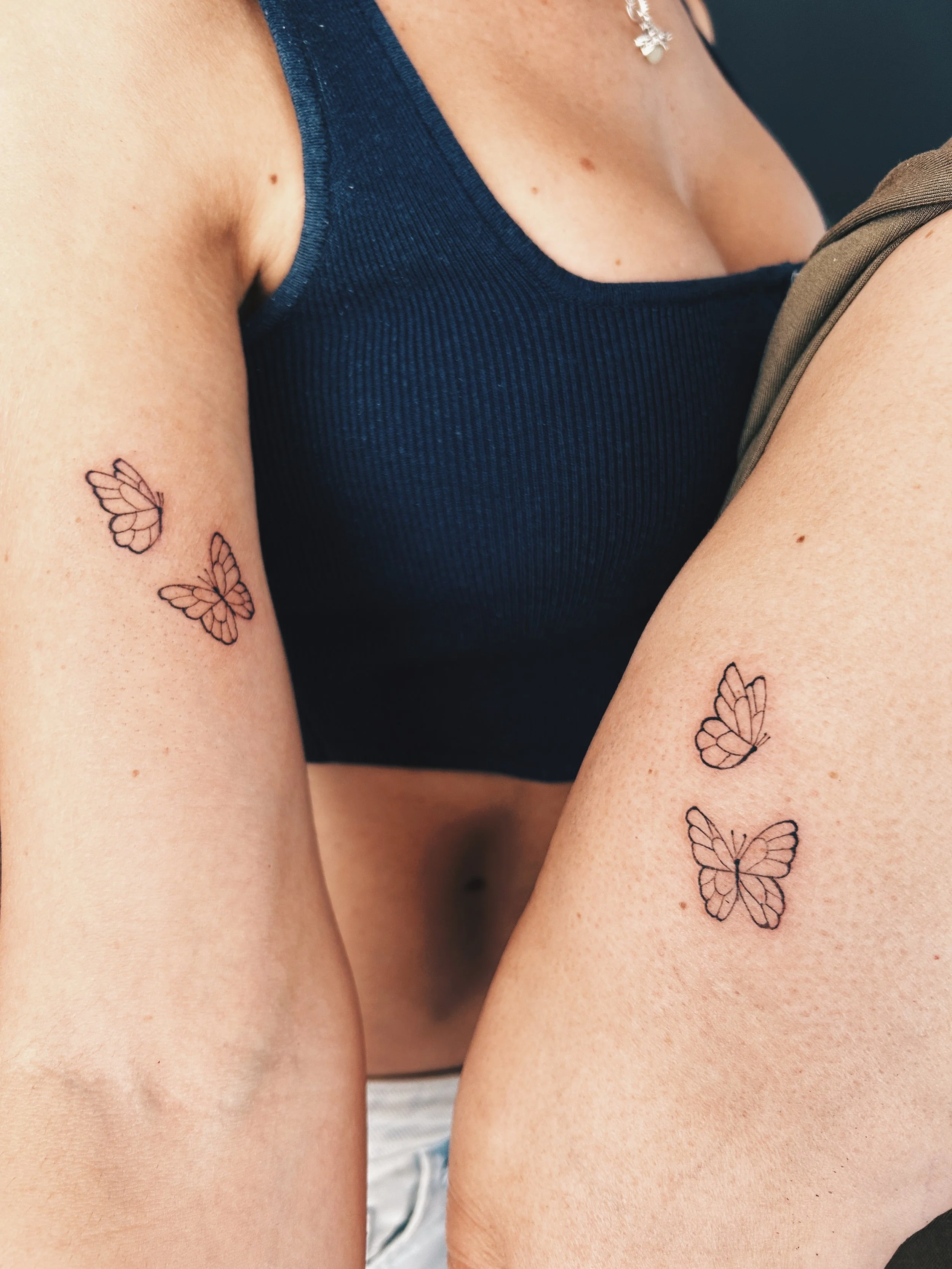 Tatuajes Fine Line de mariposas a juego realizados por Manuela Medina en Purezas Tattoo