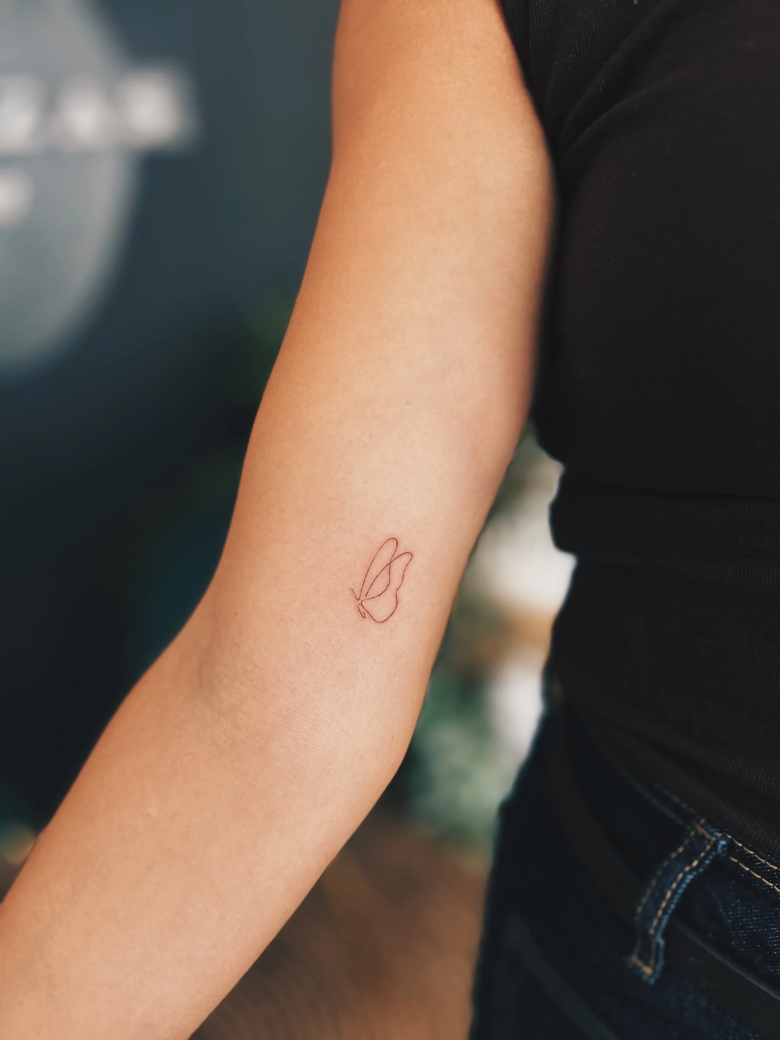 Tatuaje Fine Line silueta mariposa realizado por manuela medina en purezas tattoo