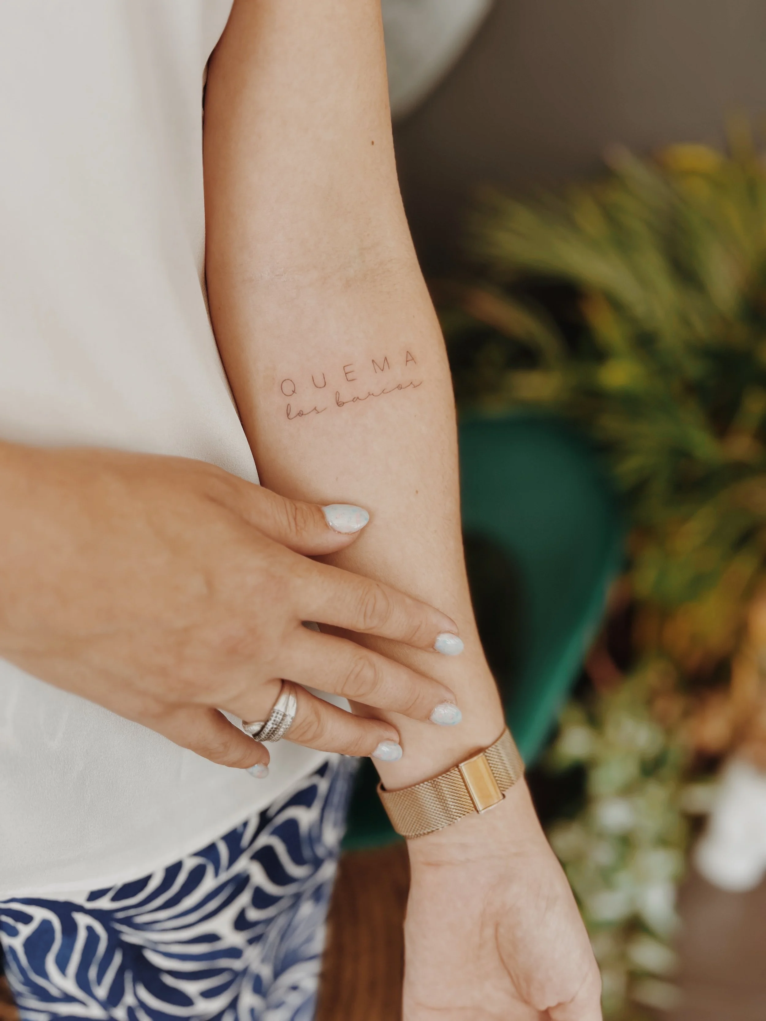 Tatuaje Fine Line con la frase “Quema los barcos” realizado por Manuela Medina en Gandía