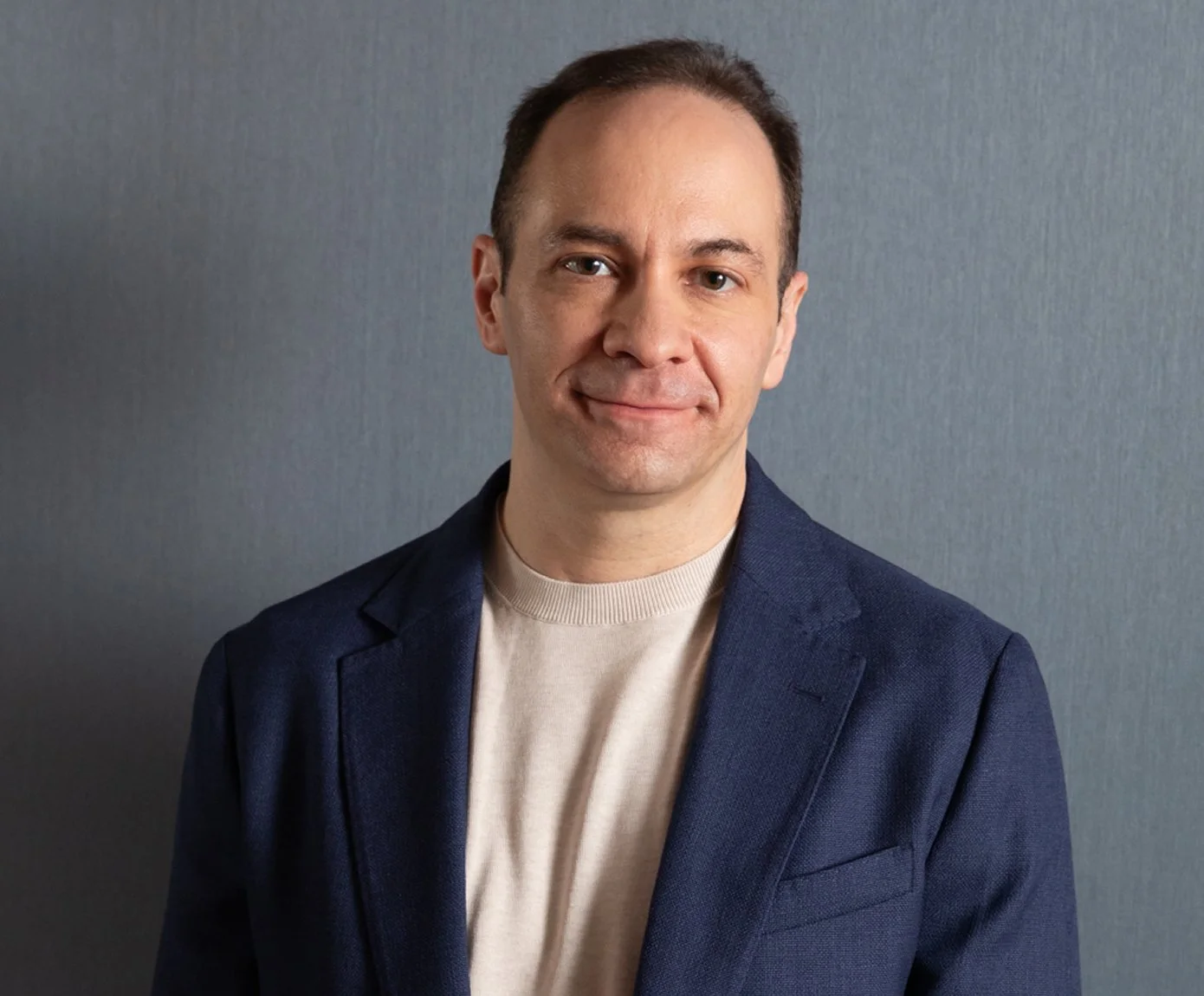 Ron Friedman wearing a navy blazer and a friendly smile