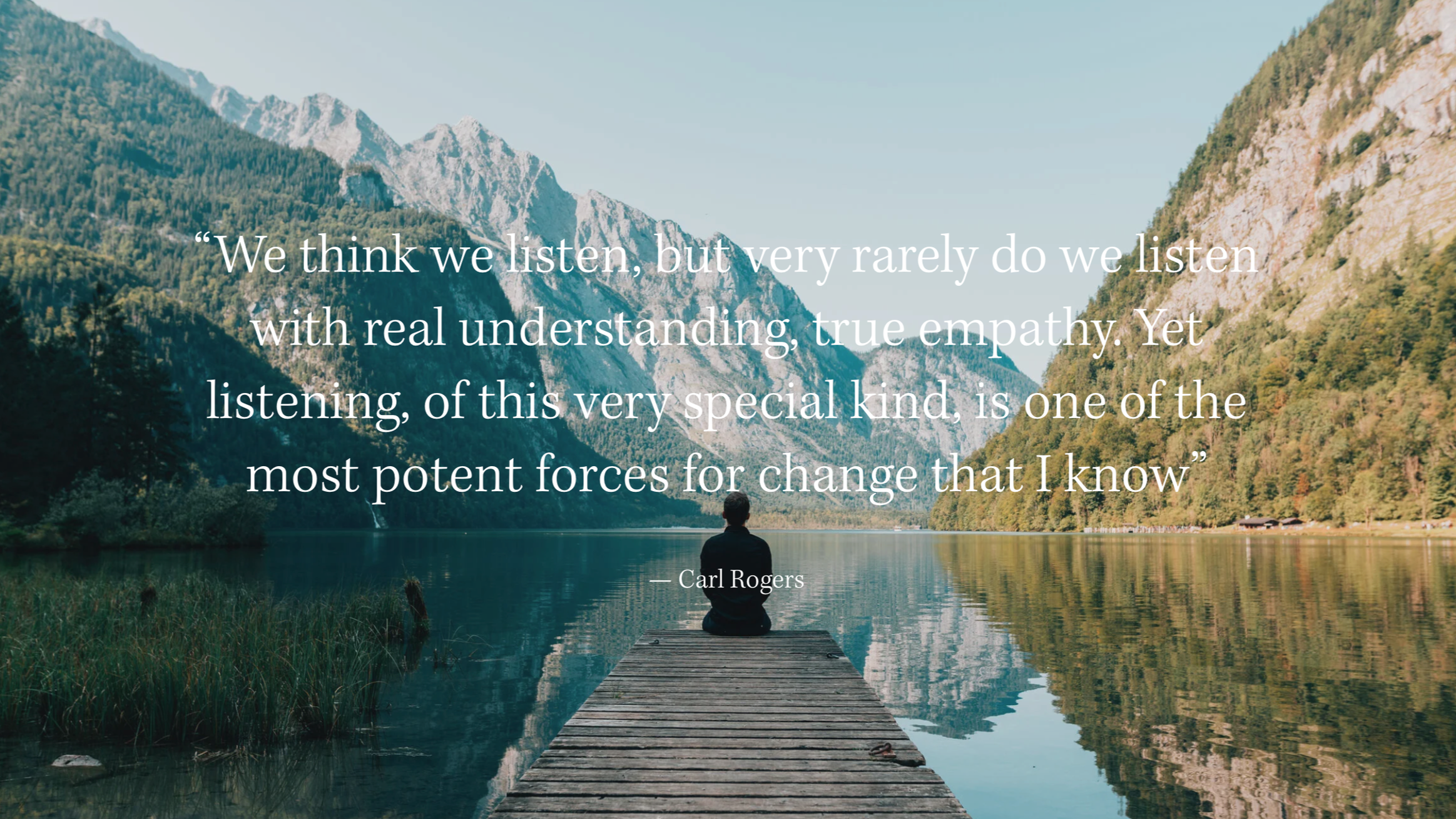 A person meditating on a wooden dock that extends into a calm lake surrounded by mountains and forest, with overlaid inspirational quote.