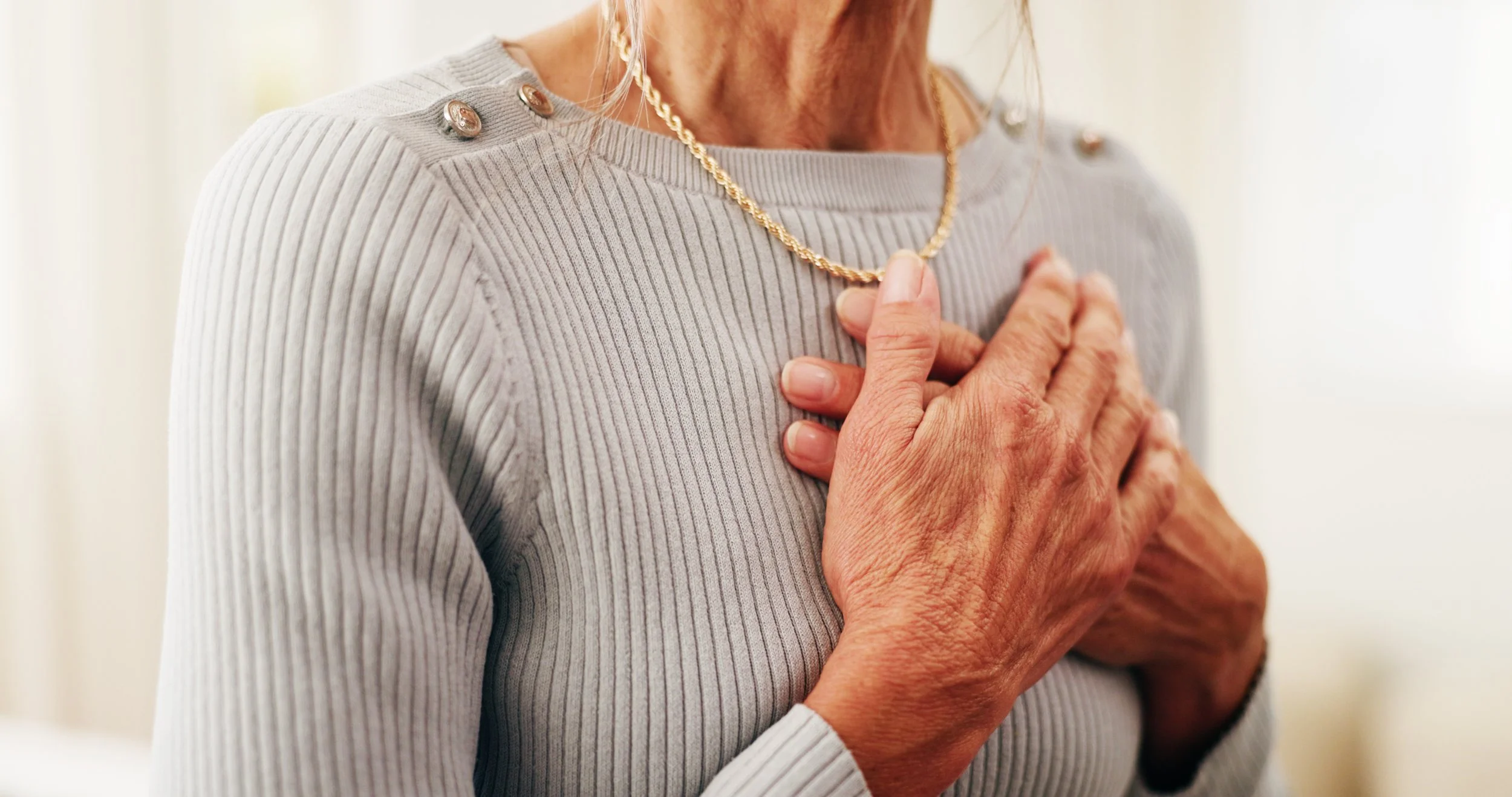 Senior woman with hands on her heart in self-love