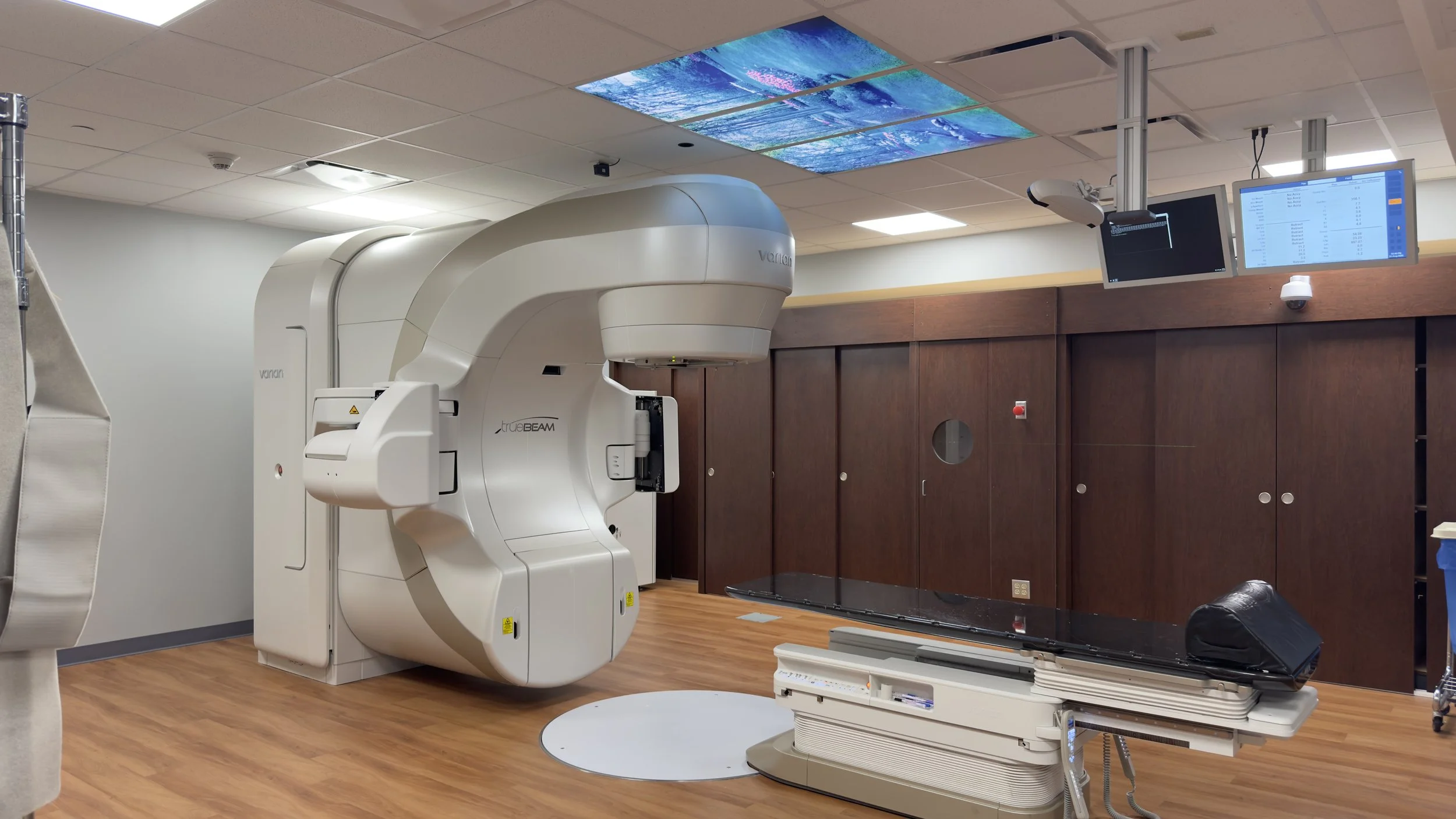 Completed St. Mary’s Medical Center radiation oncology suite with a Varian TrueBeam linear accelerator, treatment table and equipment monitors.