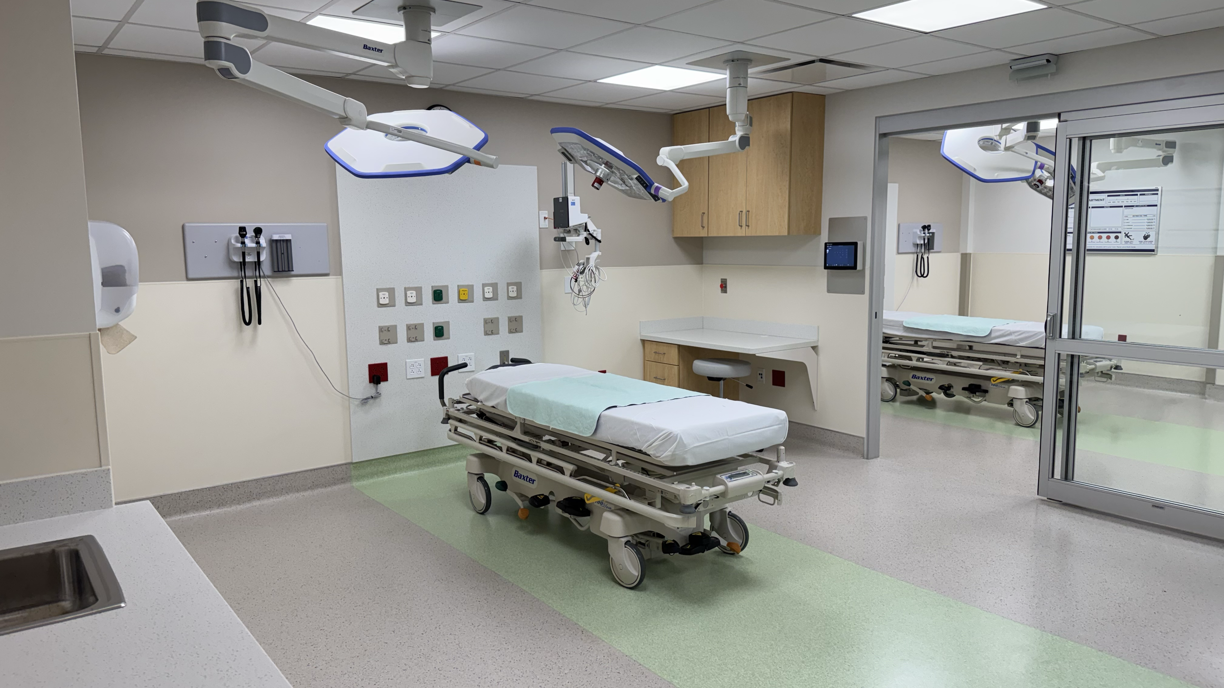 Rivers Health emergency department treatment room with patient beds, medical equipment, built-in cabinetry, and clinical lighting in Point Pleasant, West Virginia.