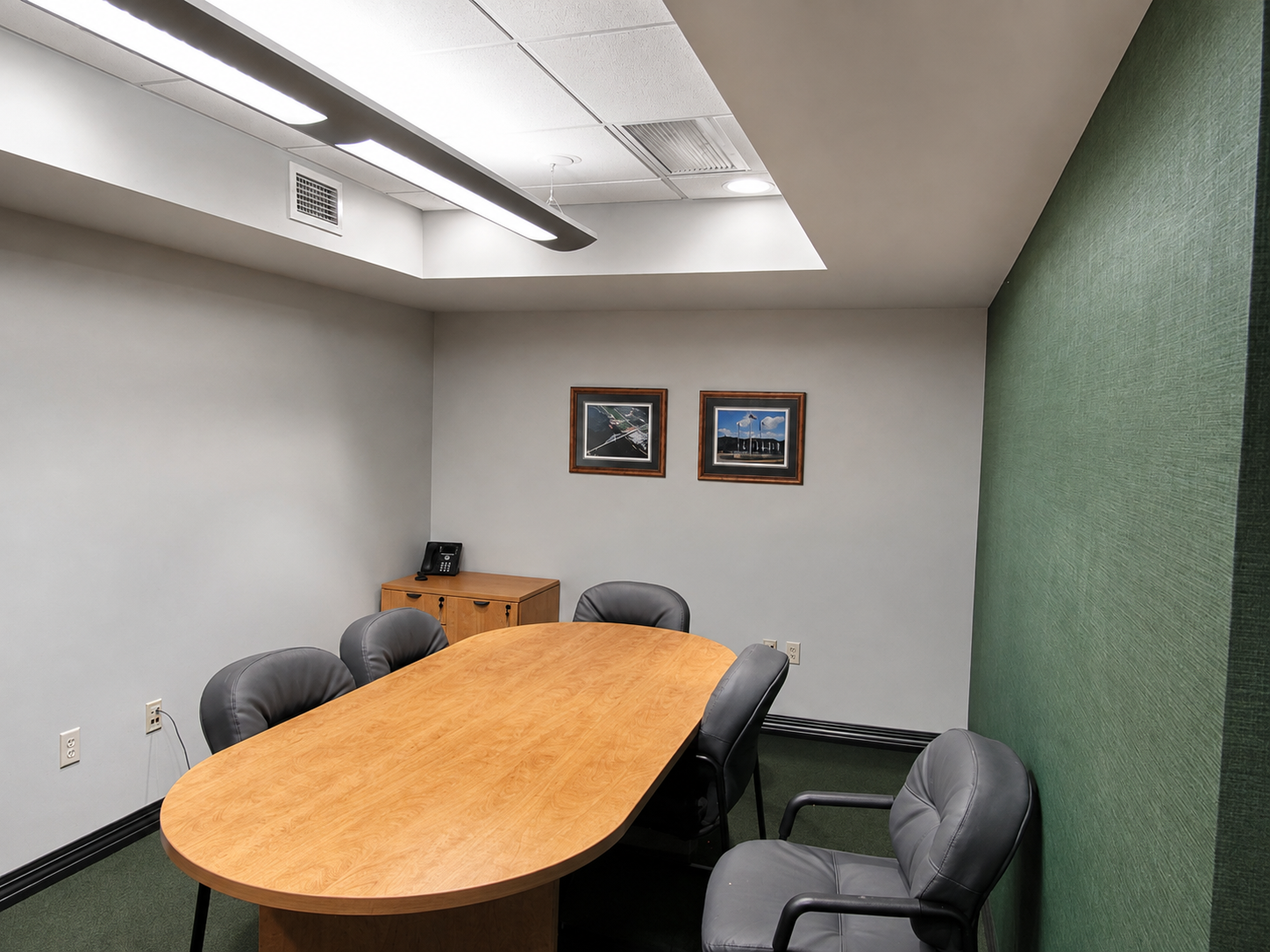 DESCO Federal Credit Union conference room featuring a wood meeting table, seating and green accent wall.