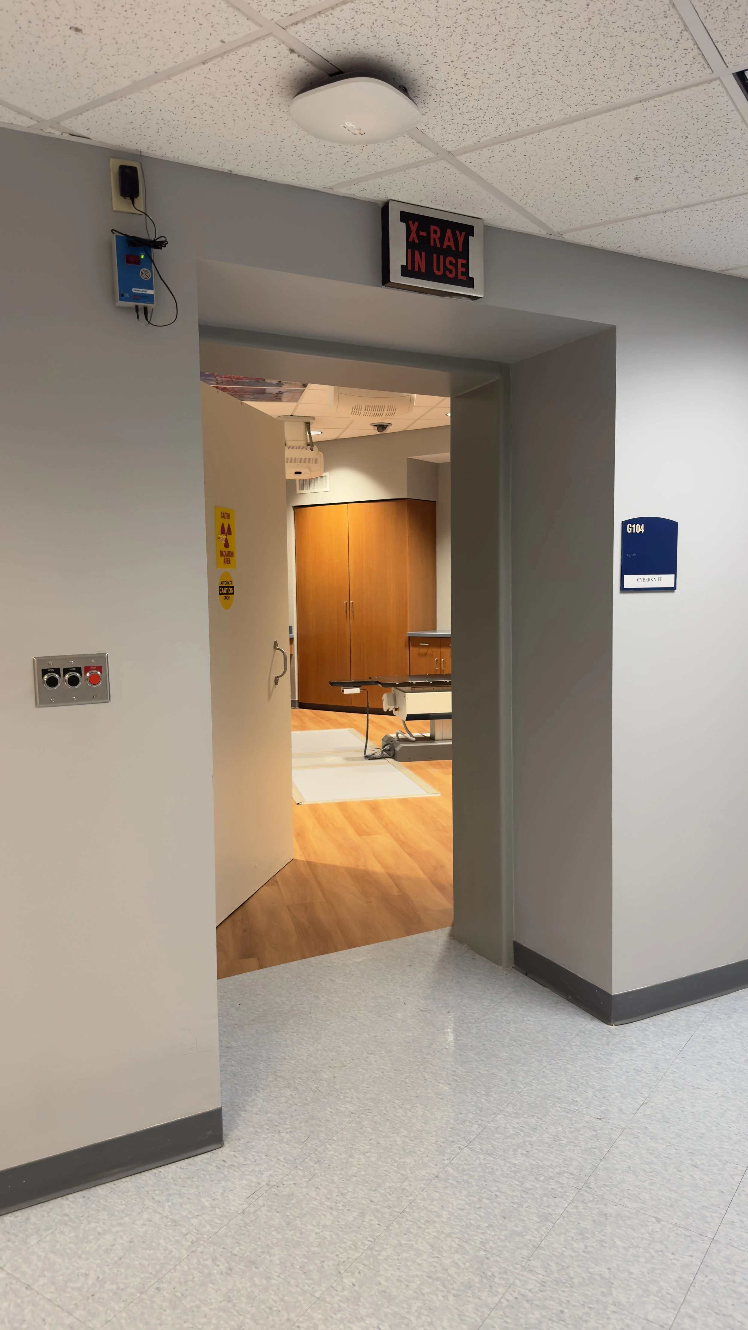 Entrance to the CyberKnife treatment room with an illuminated X-ray-in-use warning sign.