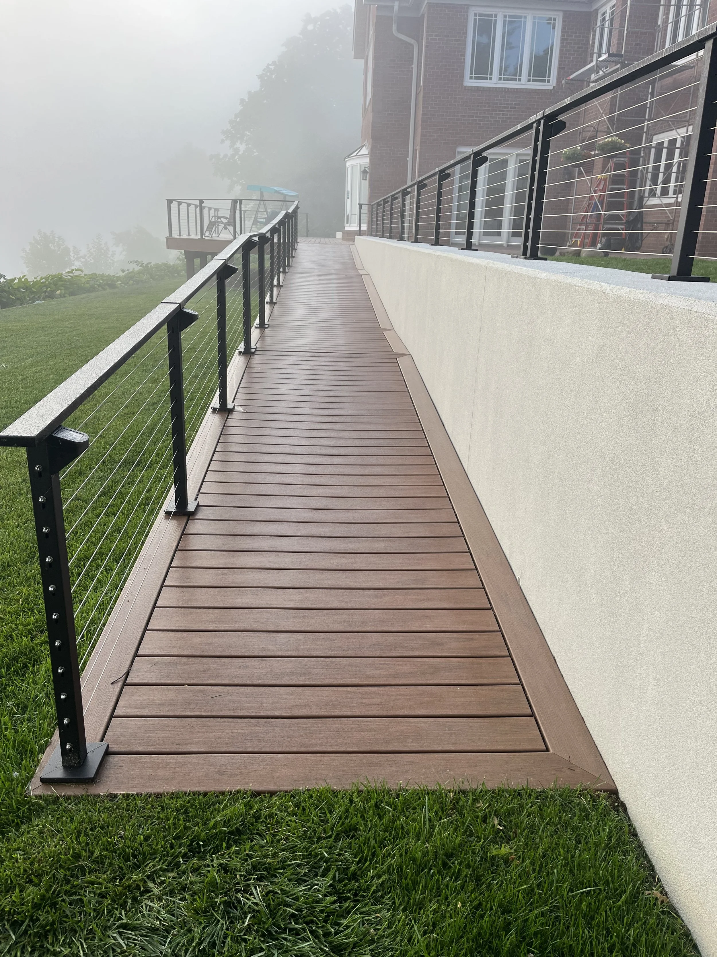 Completed riverfront walkway with cable railing and retaining wall at the Pallottine Sisters project.