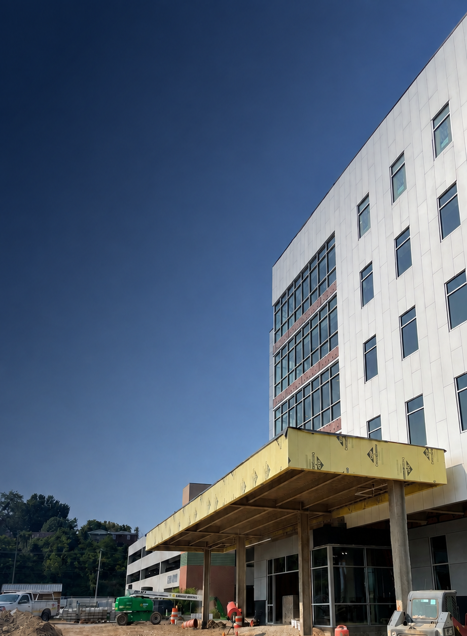 Commercial building under construction with a large entrance canopy during design-build construction.