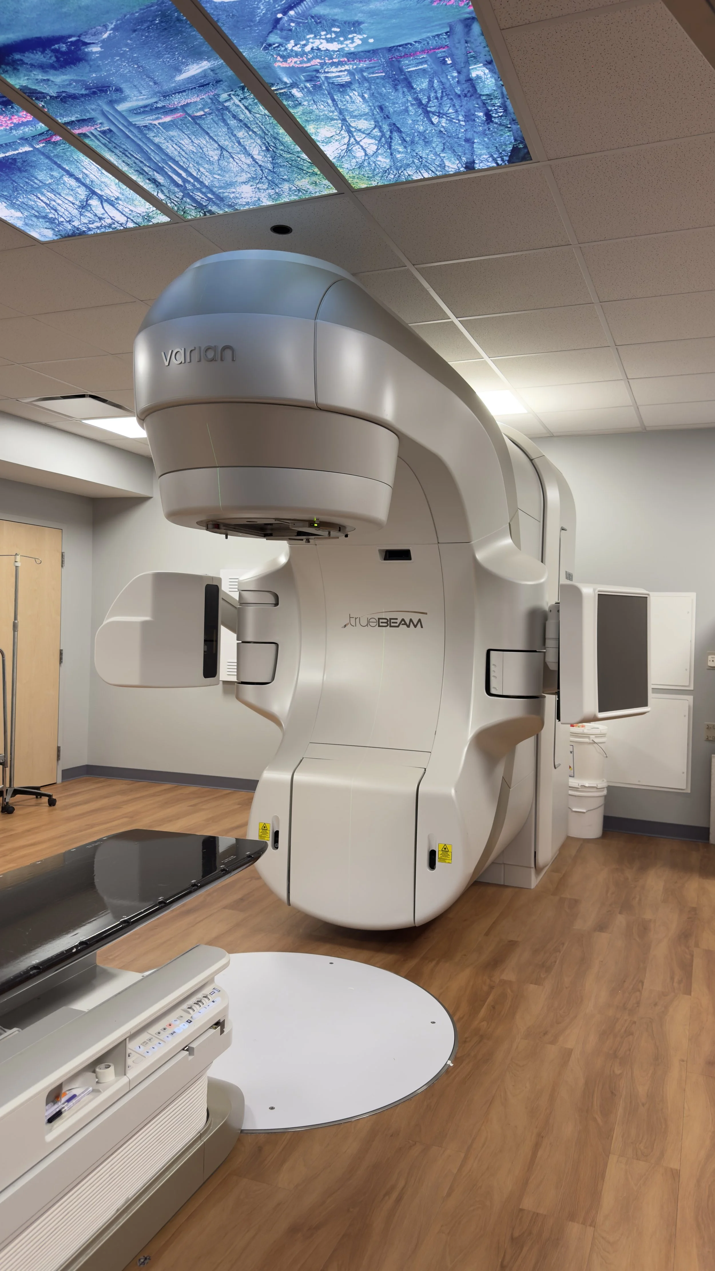 Varian TrueBeam radiation-treatment system beneath illuminated nature ceiling panels at St. Mary’s Medical Center.
