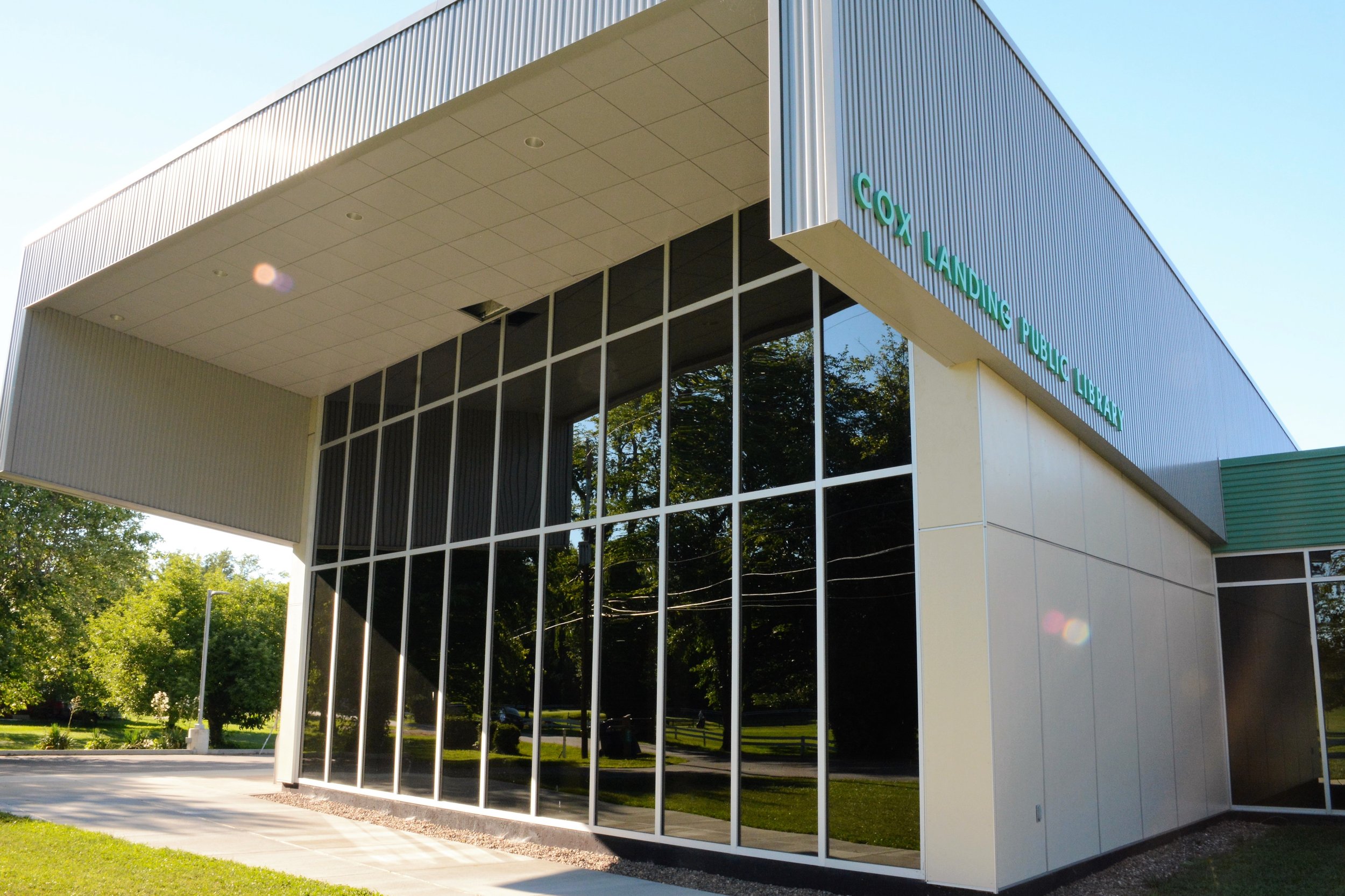 Cox Landing Branch Library showing its contemporary exterior and corner curtain-wall glazing.