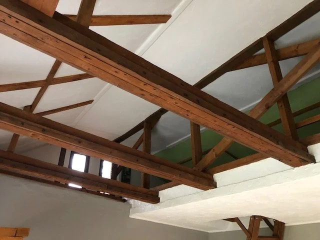 Innenseite eines Hauses mit sichtbaren Holzbalken und Decken.