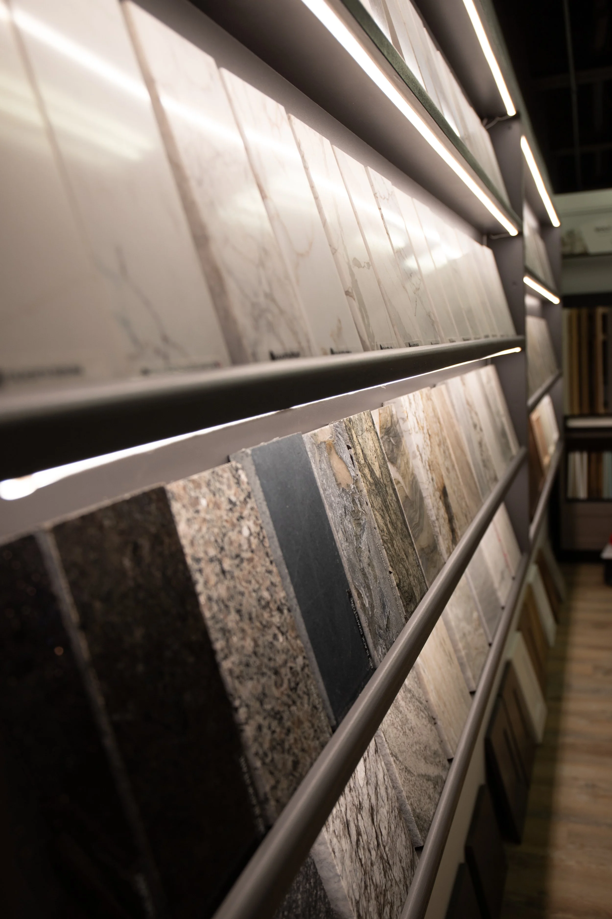 Display of various tile samples on shelves in a showroom.