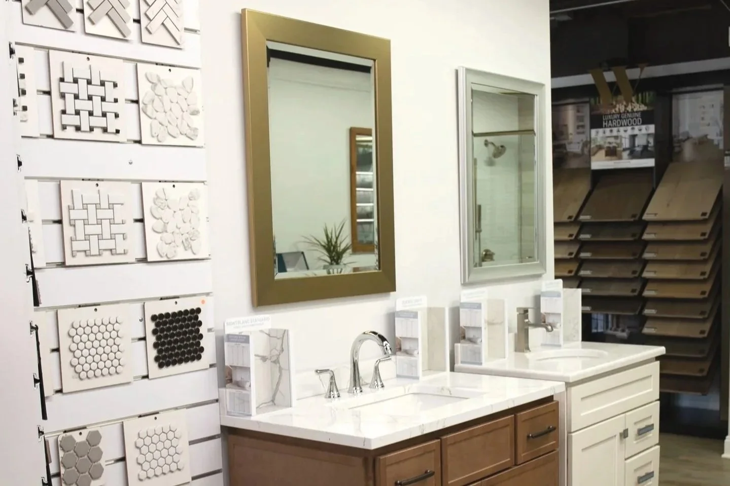 Bathroom vanity area with two sinks, two mirrors, and display of tile samples on wall.