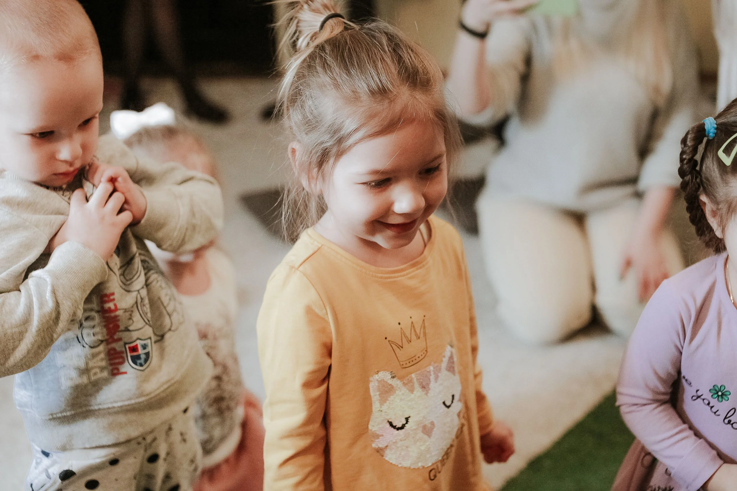 Group of young children standing close together, engaging in an activity, with expressions of concentration and happiness. This represents children's church and nursery at the faith center church in Snead, Alabama.