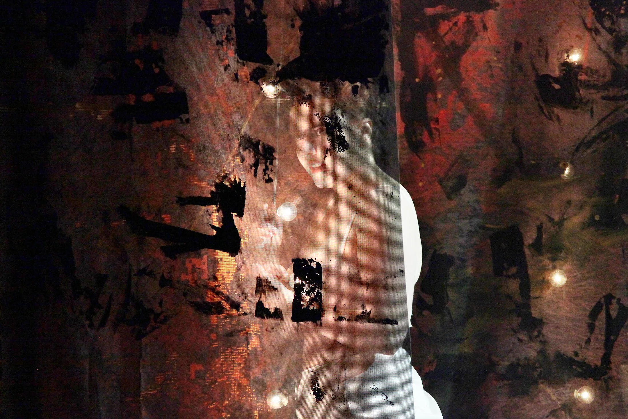Wall mural of a woman holding a glass, reflected on a dark, textured ceiling with lights.