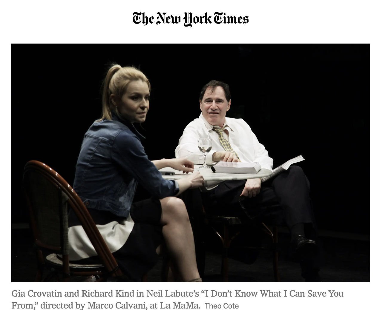 Gia Covatin and Richard Kind performing in Neil Labute’s ‘I Don’t Know What I Can Save You From’ at La MaMa, sitting at a small table with glasses and papers against a black background.