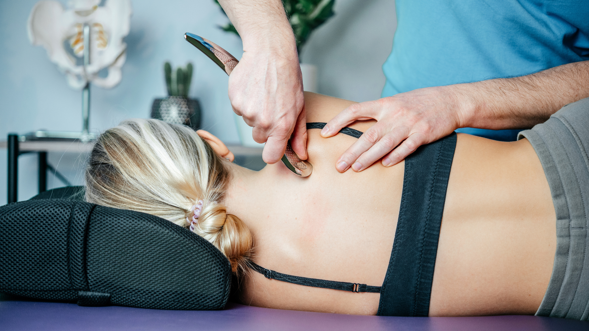A person receiving a chiropractic adjustment on their neck, specifically a Graston Technique, which is used at Psota Chiropractic in Overland Park, KS