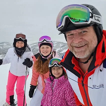 Dr. Psota, OP Chiropractor, enjoying skiing and family time on snowy mountain.
