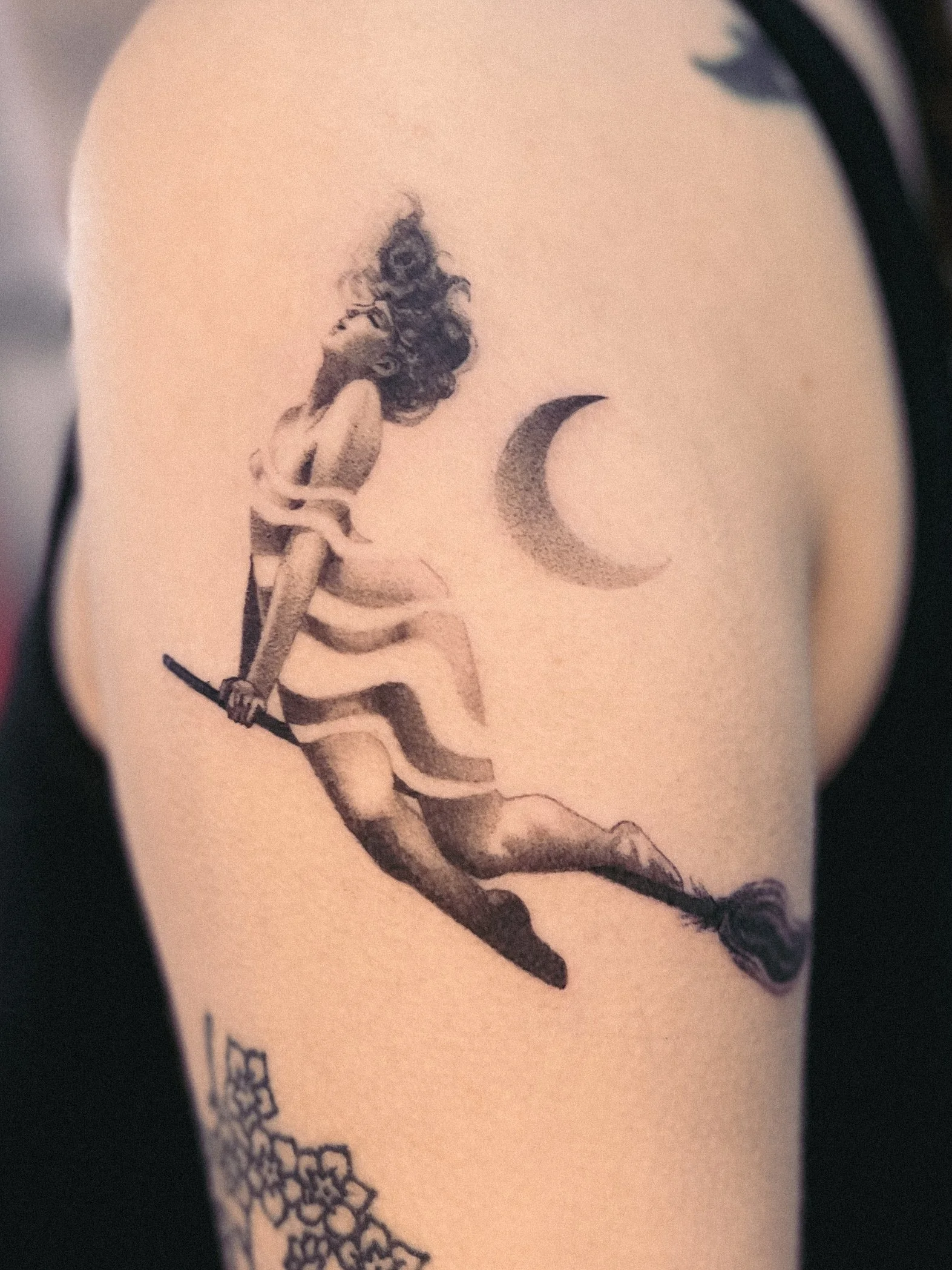 A tattoo of a woman sitting on a branch, looking upwards, with a crescent moon to the right. witchy tattoo preraphaelite witch
