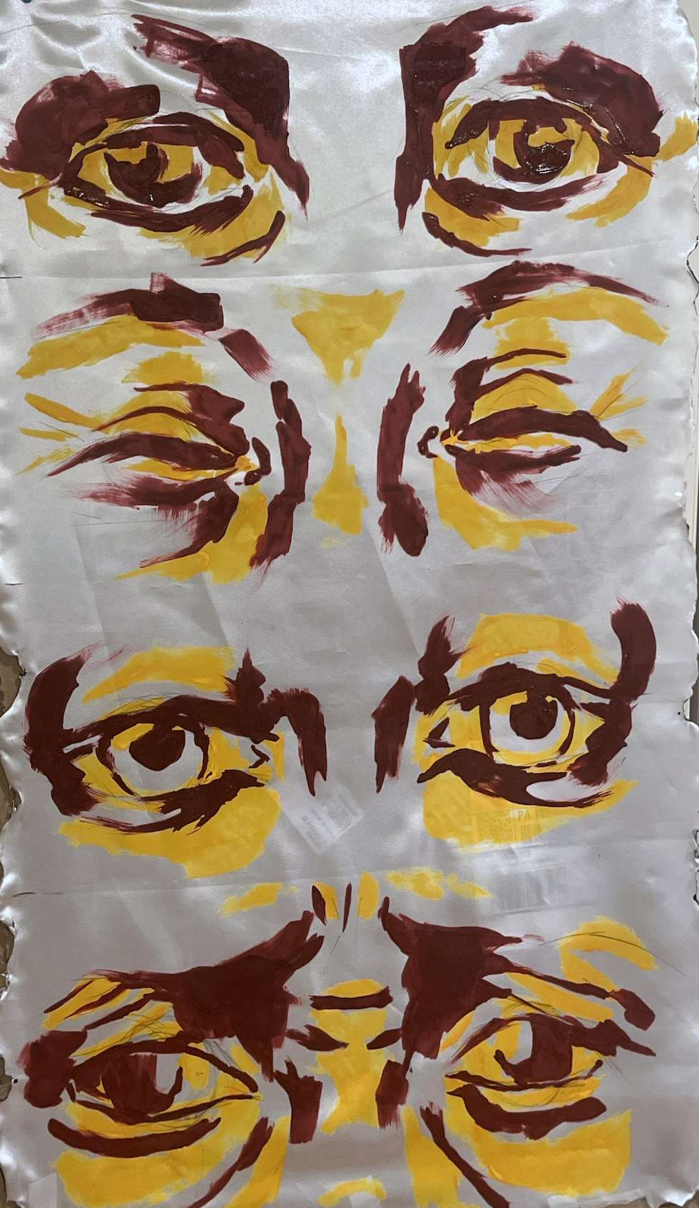 An abstract watercolor painting featuring six pairs of eyes, with prominent use of yellow and maroon colors, arranged symmetrically on a white background.