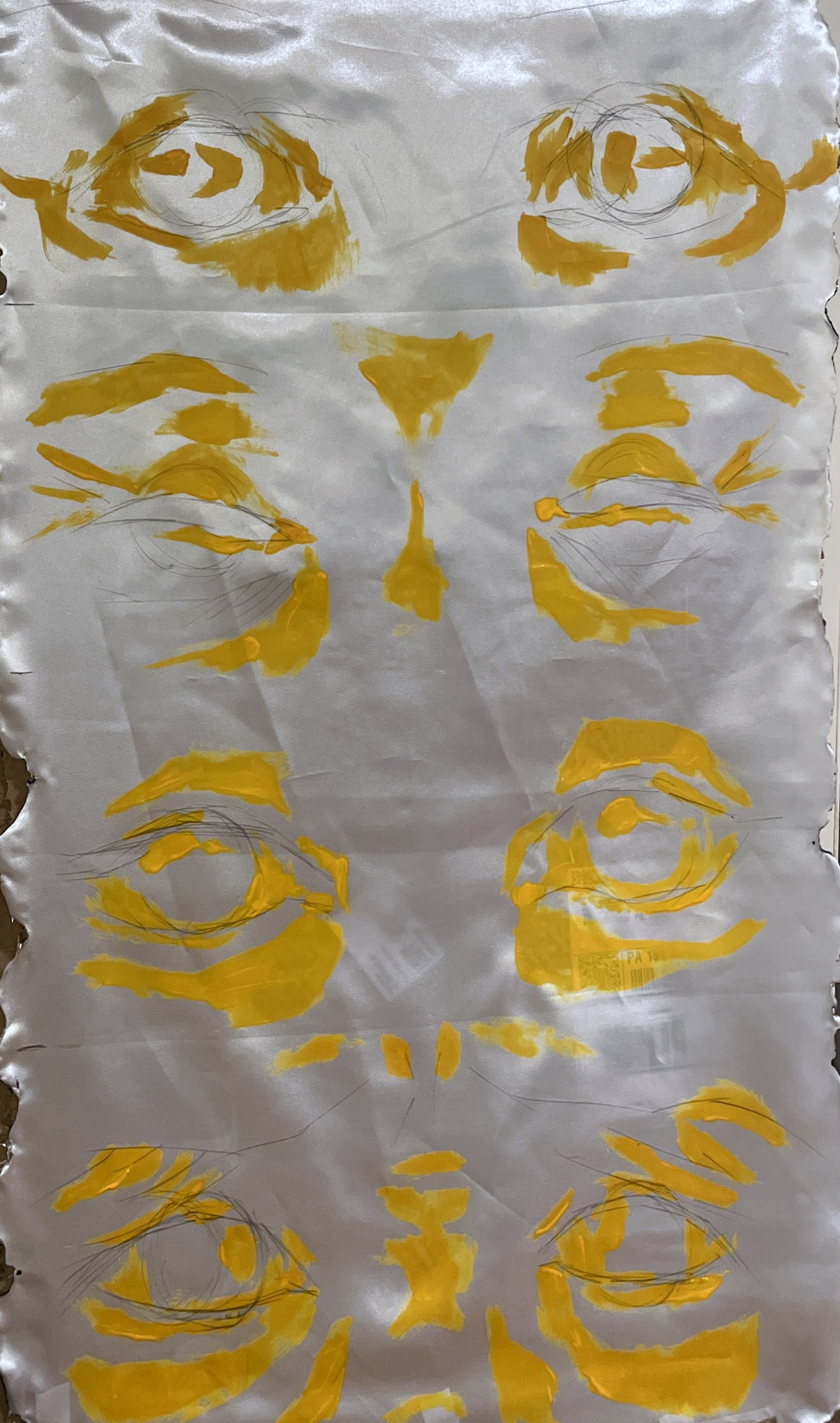 Abstract art depicting multiple yellow eye shapes and face outlines on crinkled white paper.