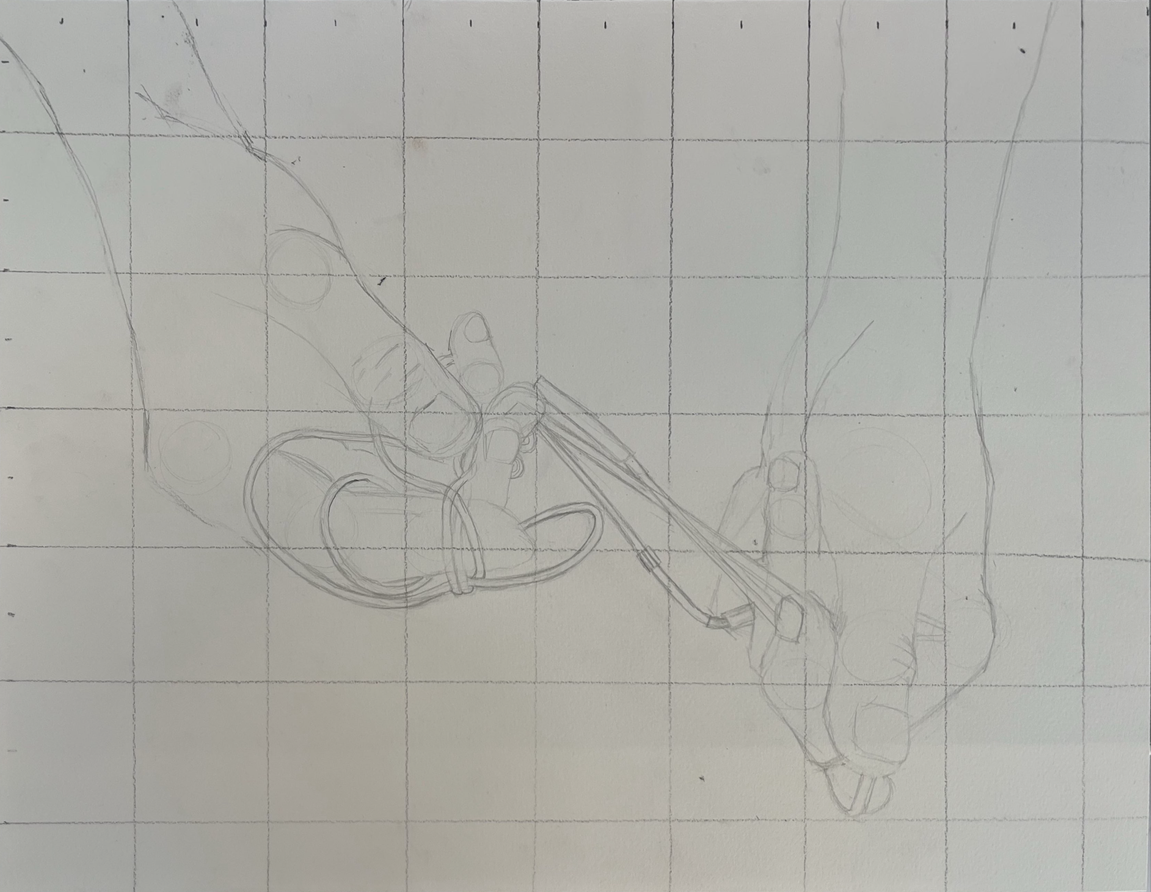 Sketch of a hand holding a pen, with multiple interconnected shapes and lines on paper with grid lines.