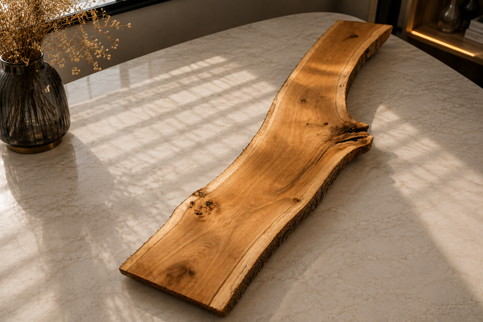 Holztablett auf weißem Marmortisch neben schwarzer Vase mit Trockenblumen, Sonnenlicht mit Schattenreflexionen.