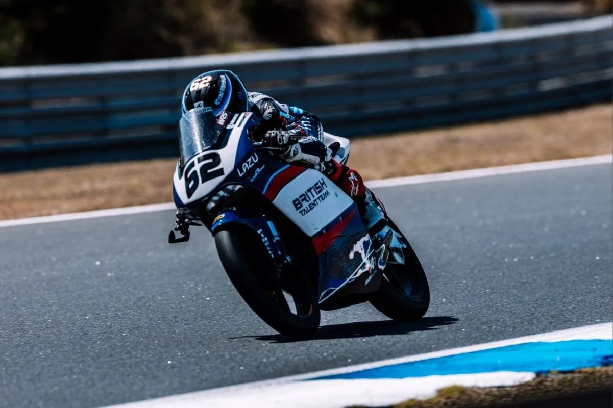 Motorcycle racer leaning into a turn on a race track.