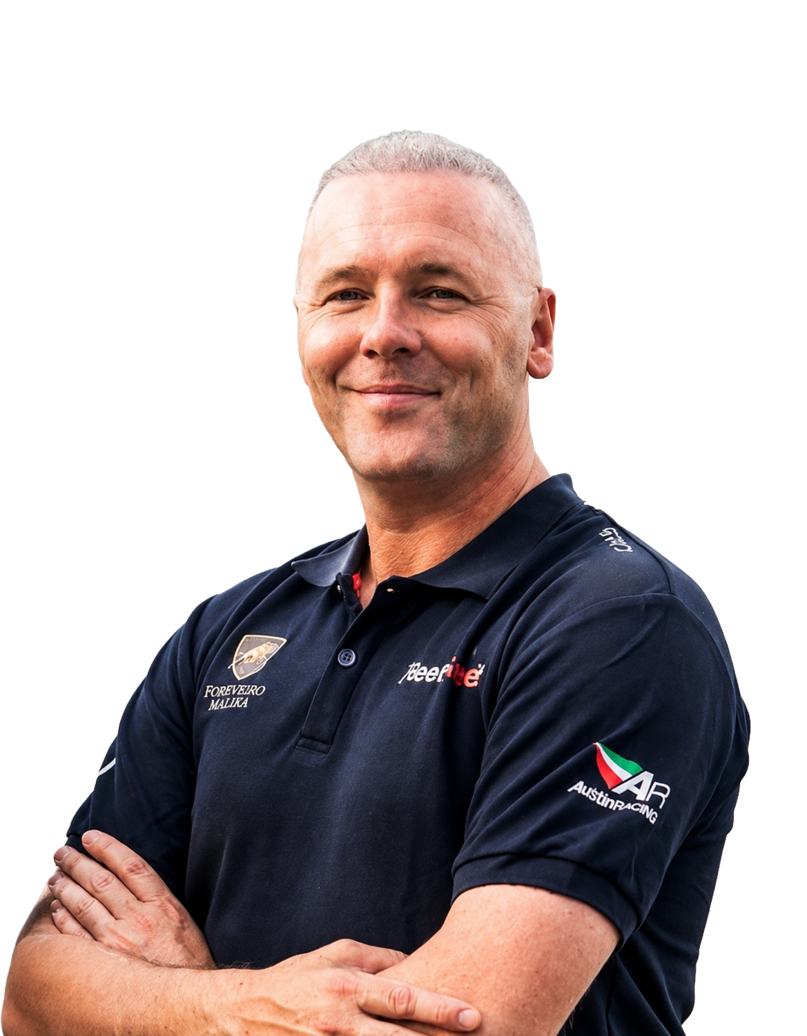 Smiling man with short gray hair in a navy blue polo shirt with sponsor logos, arms crossed, facing slightly right.