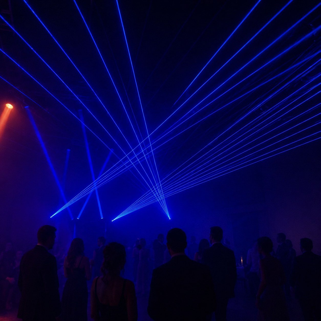 Blue laser lights at a nightclub with silhouettes of people dancing and socializing