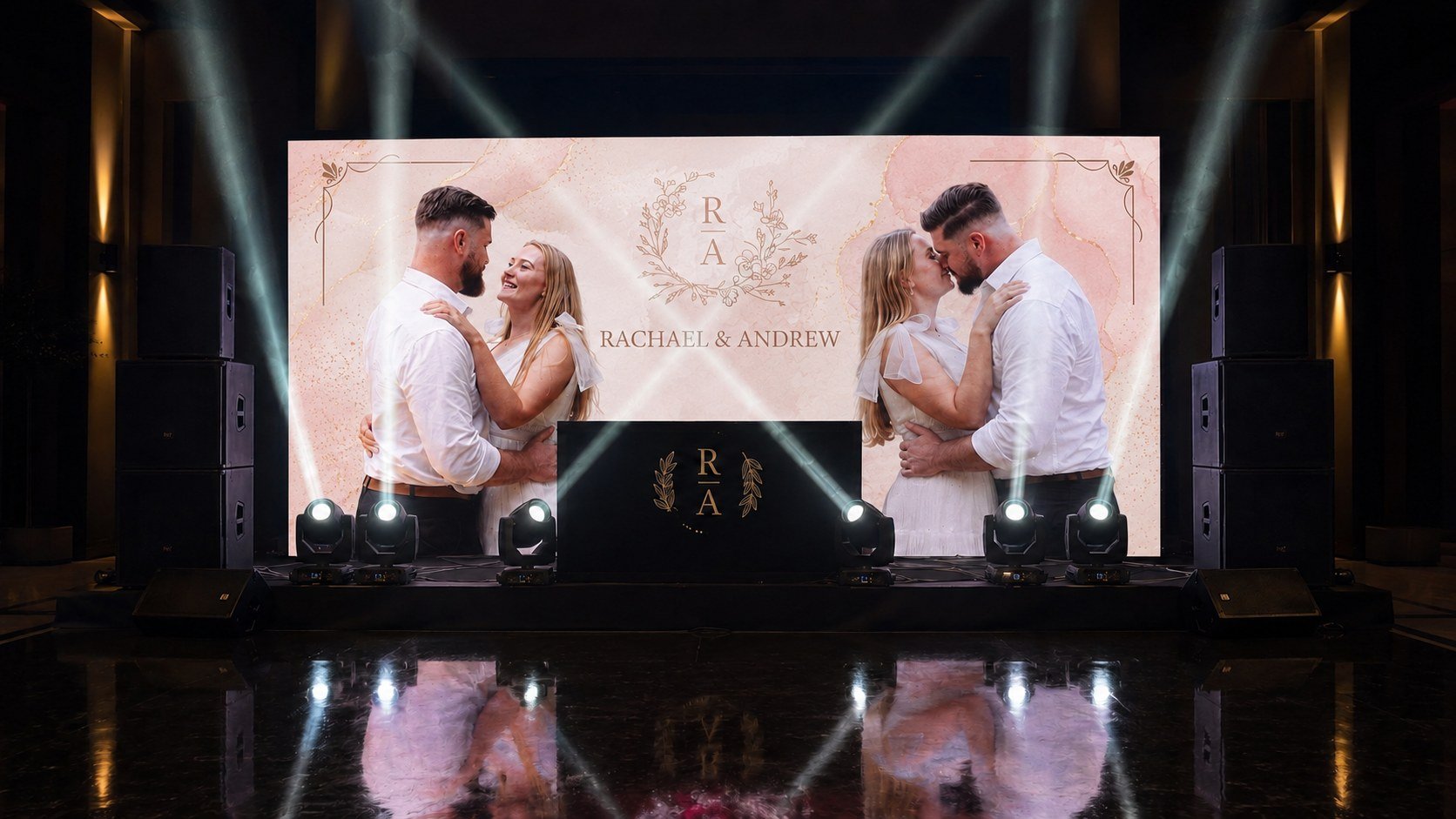 Couples dancing at a wedding reception with a large screen behind them displaying their names, Rachael and Andrew, and monogram initials R and A. The scene is decorated with elegant lighting.