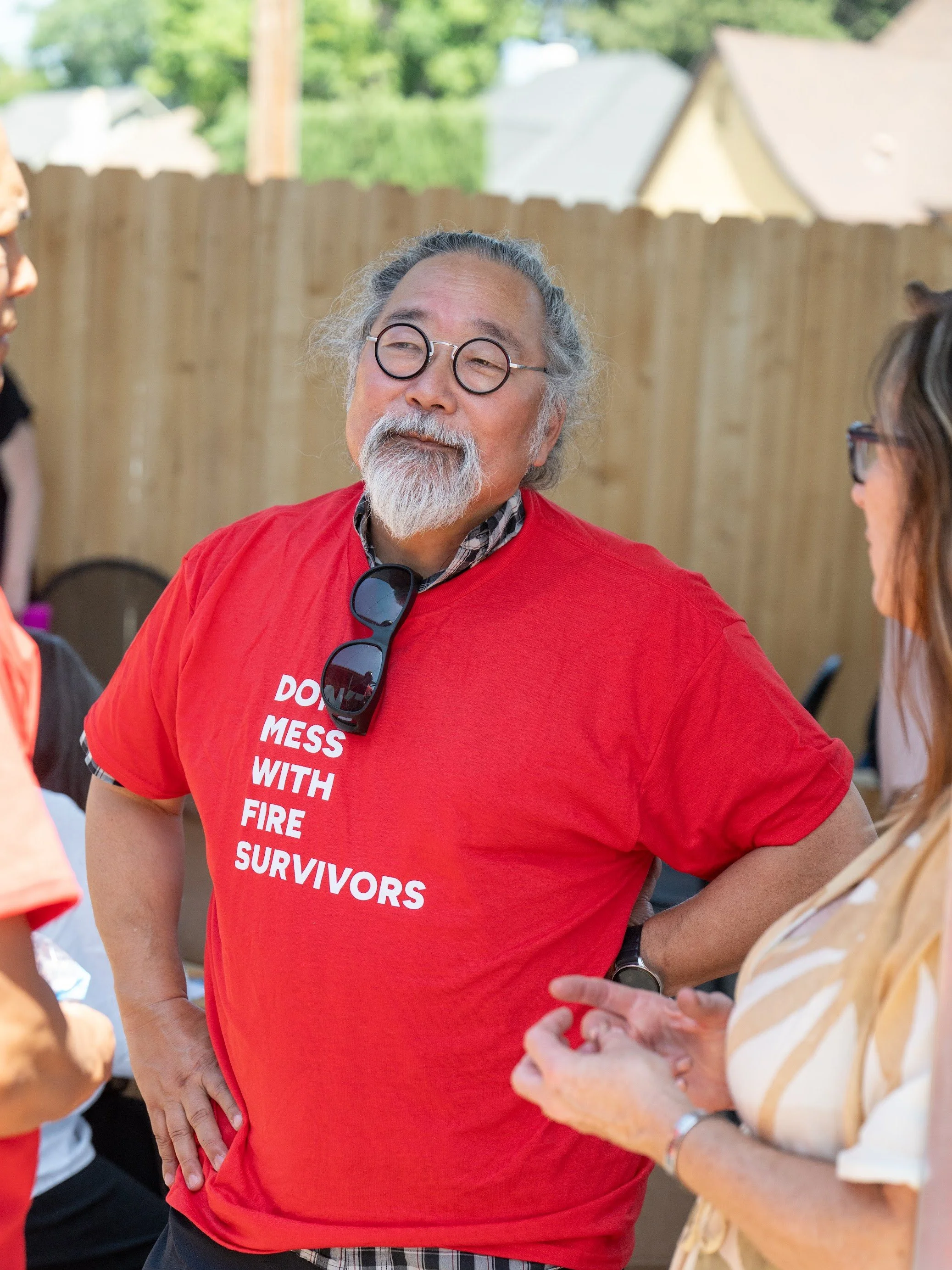 Smiling Altadena fire survivor in a red Don't Mess With Fire Survivors shirt