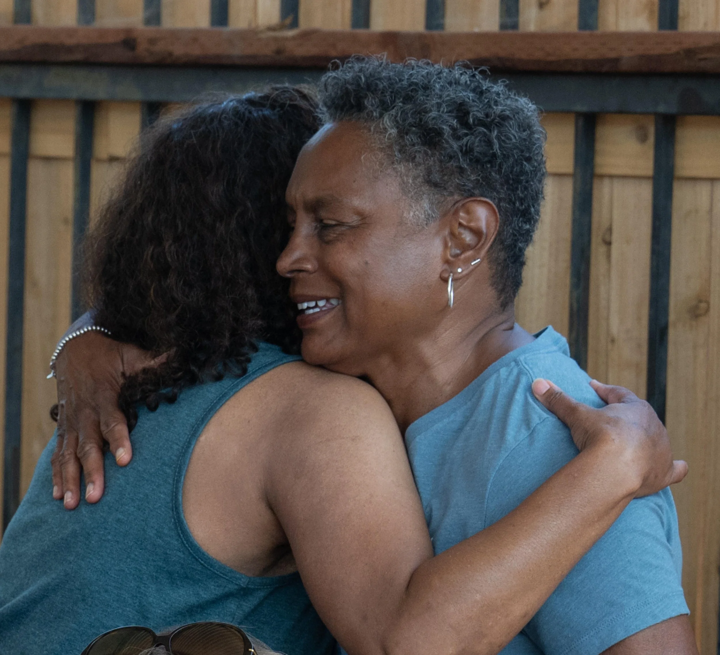 Two Eaton Fire survivors embracing warmly outdoors