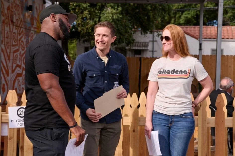 EFSN members standing together outdoors near a wooden fence, one holding papers, with an 'Altadena' shirt visible in the background