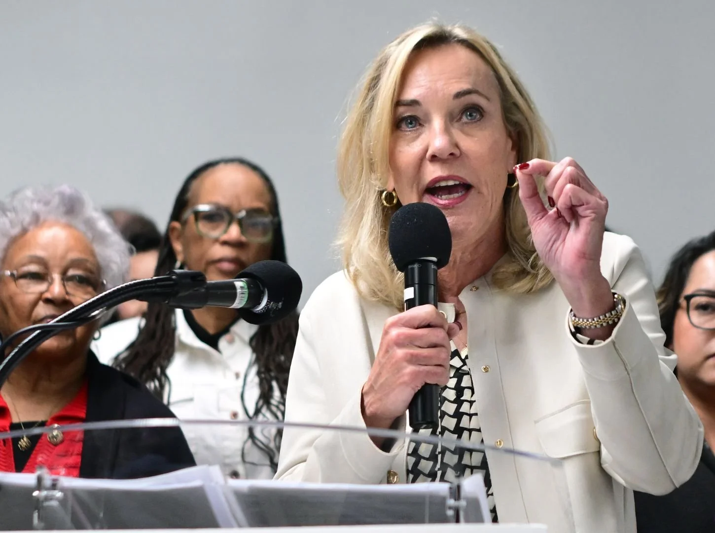 Los Angeles County Supervisor Kathryn Barger speaking at a podium, with advocates standing behind her