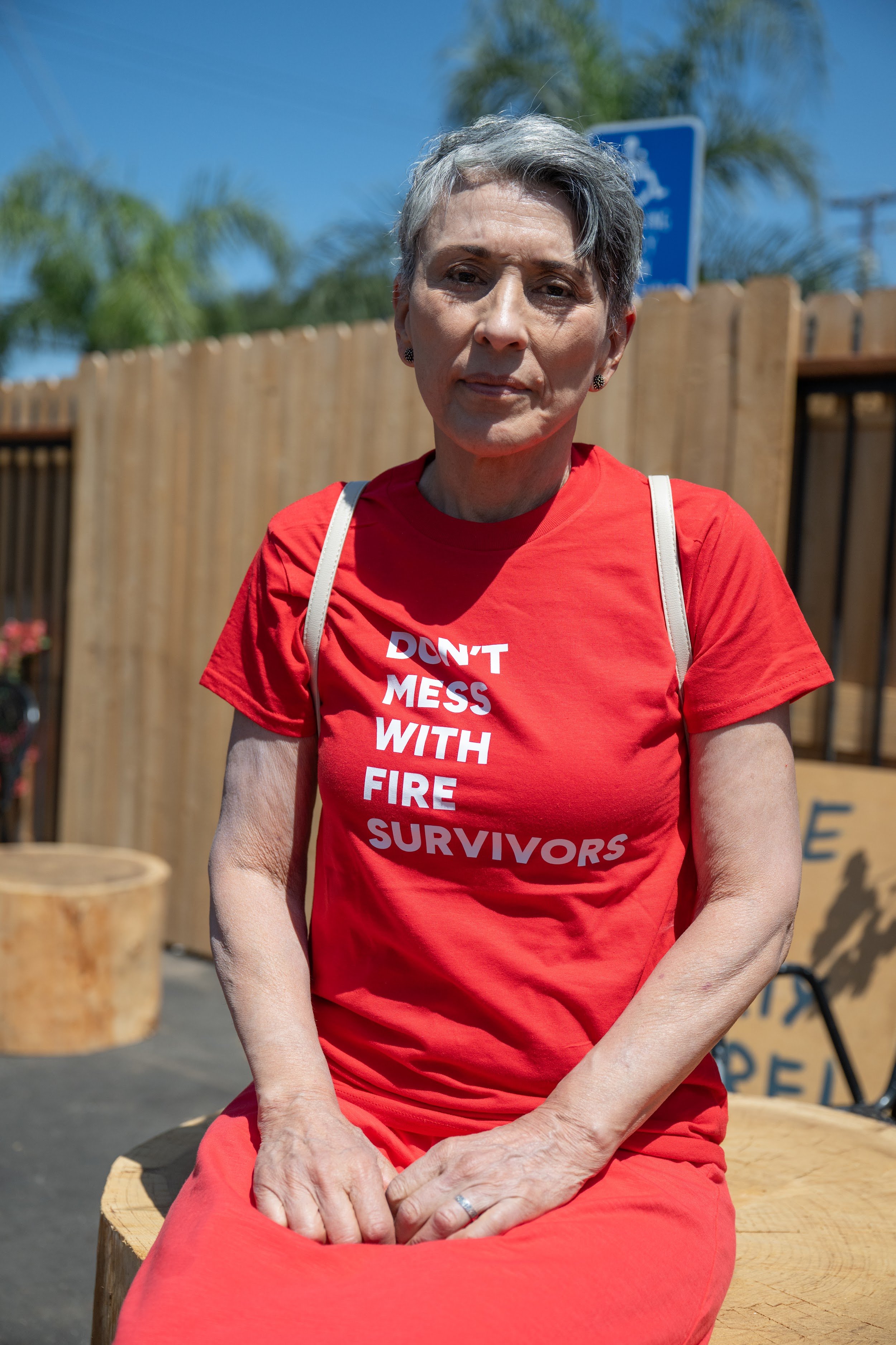 Eaton Fire survivor seated in a red Don't Mess With Fire Survivors shirt