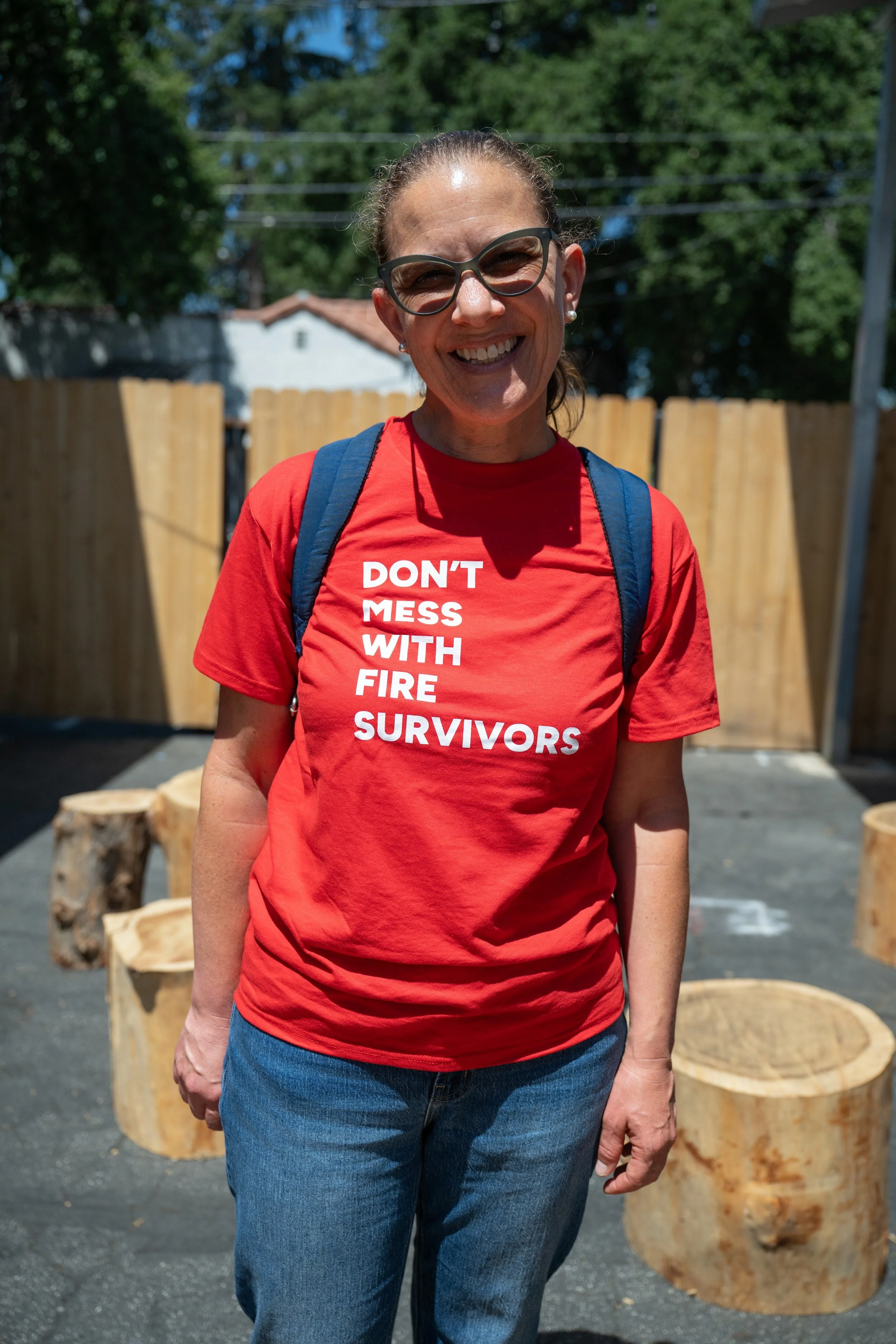 Smiling fire survivor wearing a red Don't Mess With Fire Survivors shirt