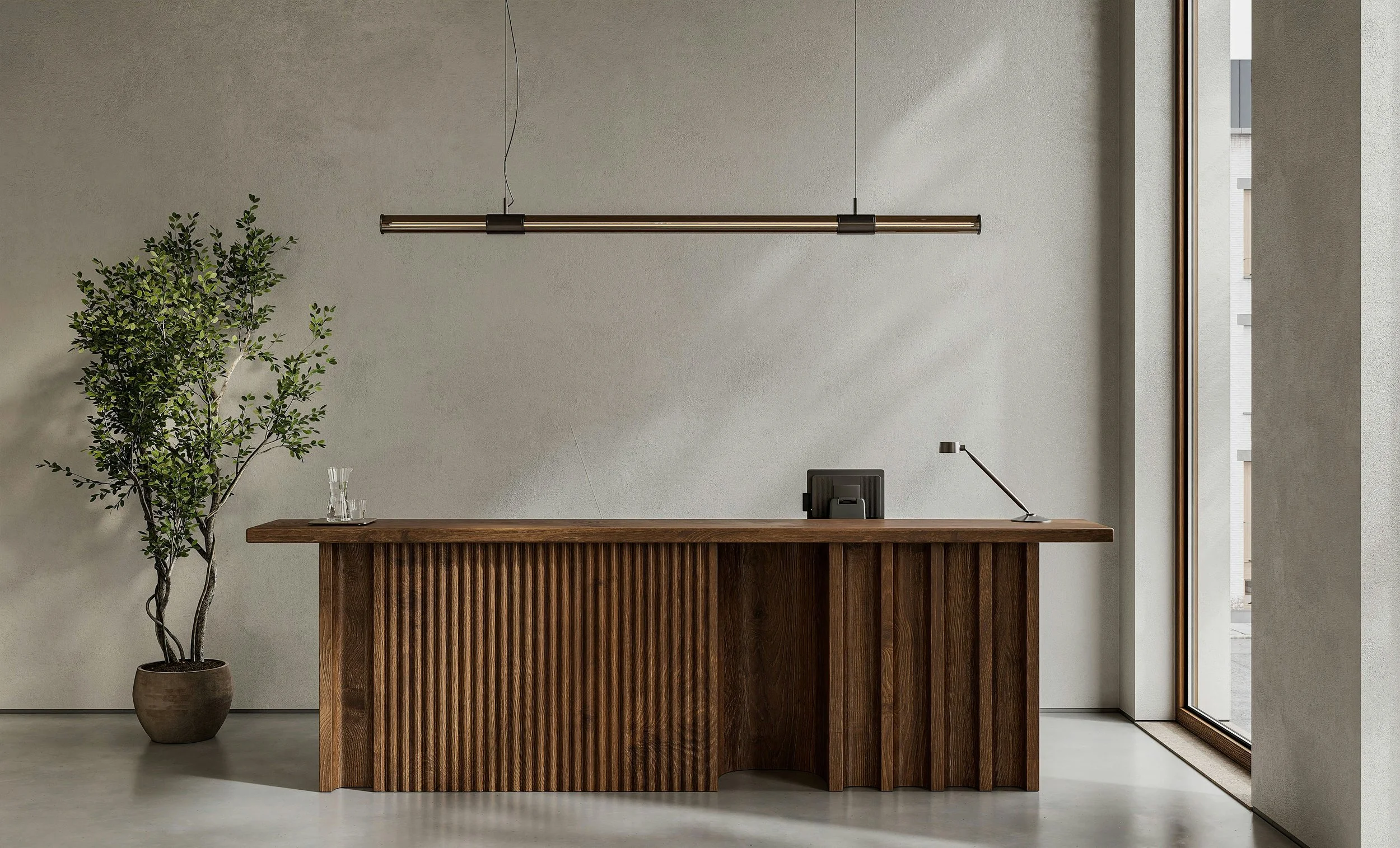 Un bureau en bois avec un ordinateur, une lampe, une plante verte dans un pot et un verre d'eau, dans un intérieur moderne lumineux avec une grande fenêtre.